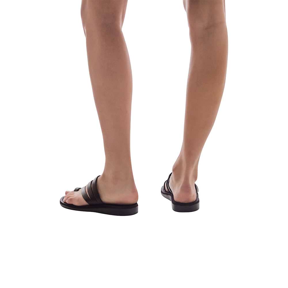 Model wearing Nora brown, handmade leather slide sandals with toe loop