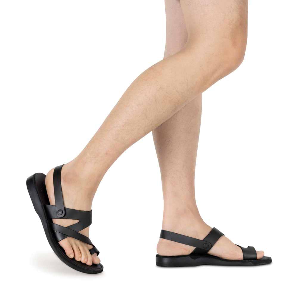 Model wearing Benjamin black, handmade leather sandals with back strap and toe loop