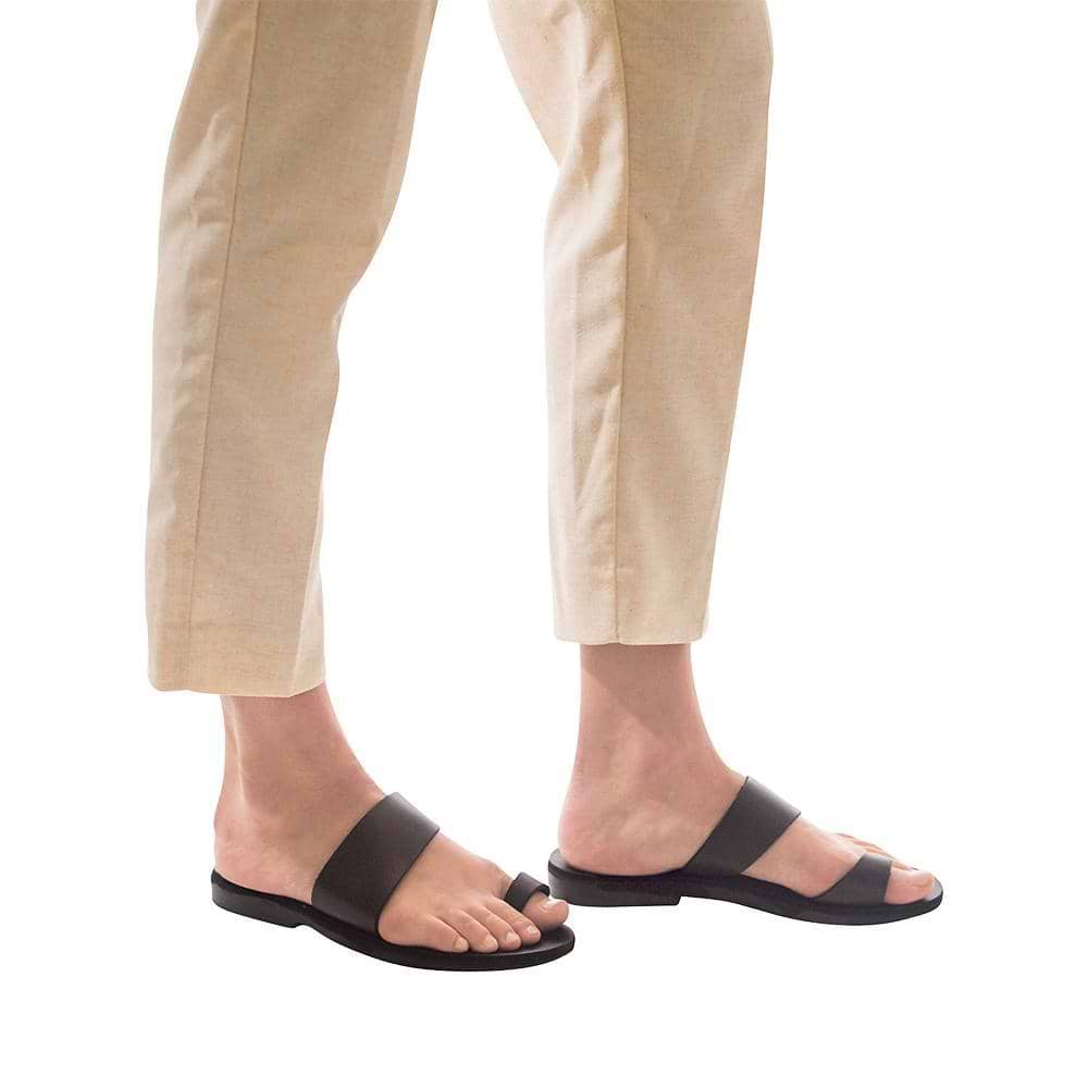Model wearing Abra black, handmade leather slide sandals with toe loop 