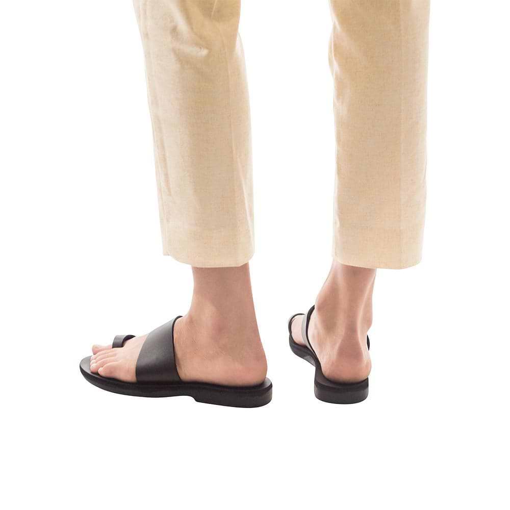 Model wearing Abra black, handmade leather slide sandals with toe loop 