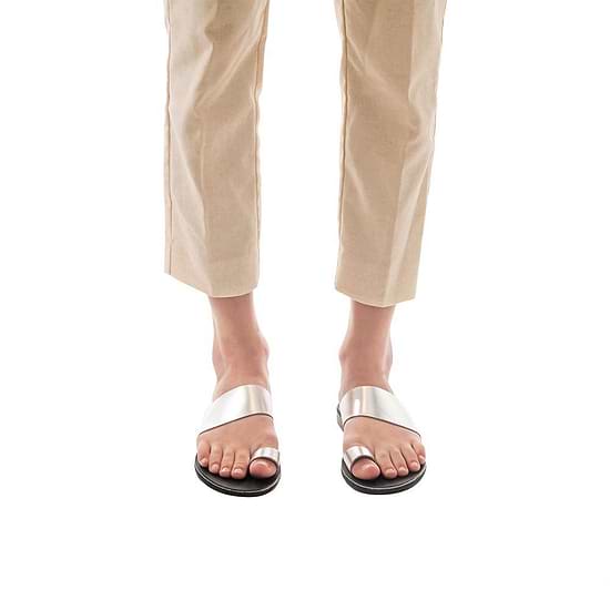 Model wearing Abra silver, handmade leather slide sandals with toe loop 