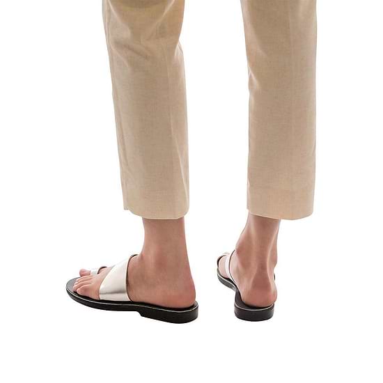 Model wearing Abra silver, handmade leather slide sandals with toe loop 