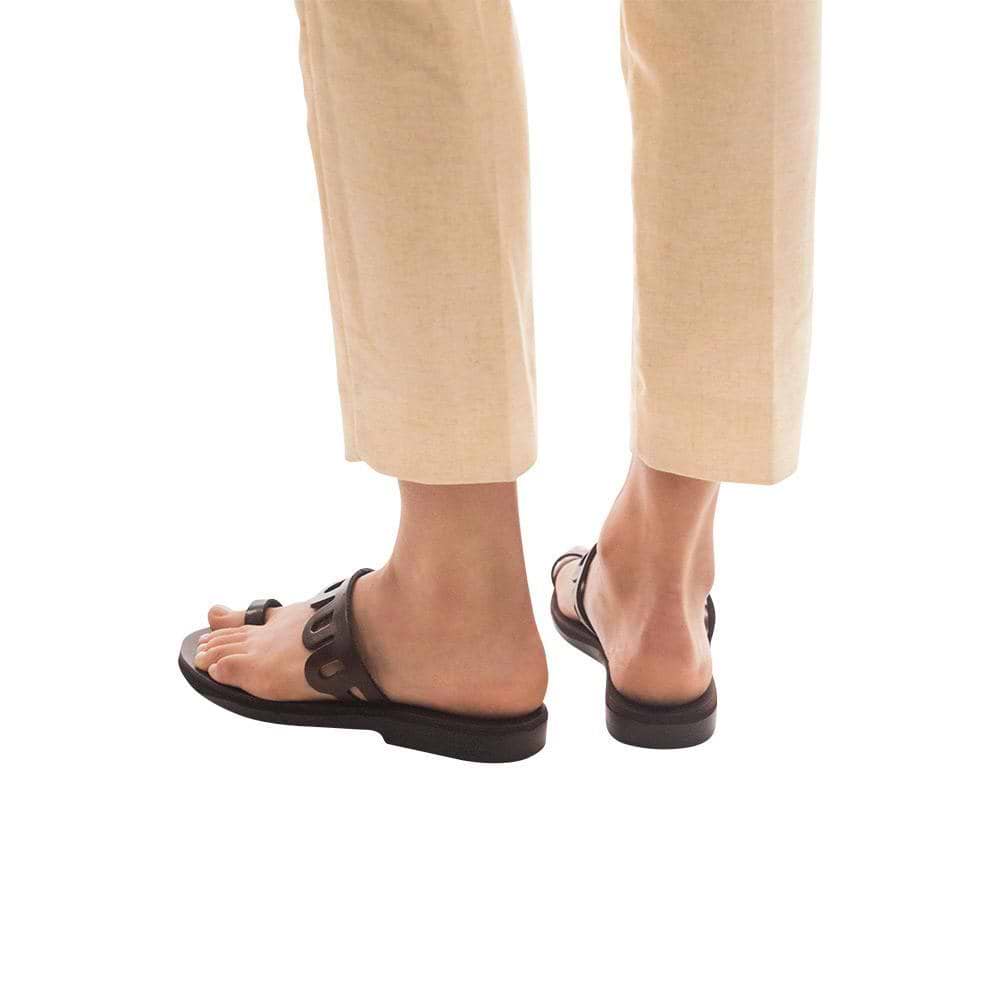 Model wearing Aja brown, handmade leather slide sandals with toe loop 