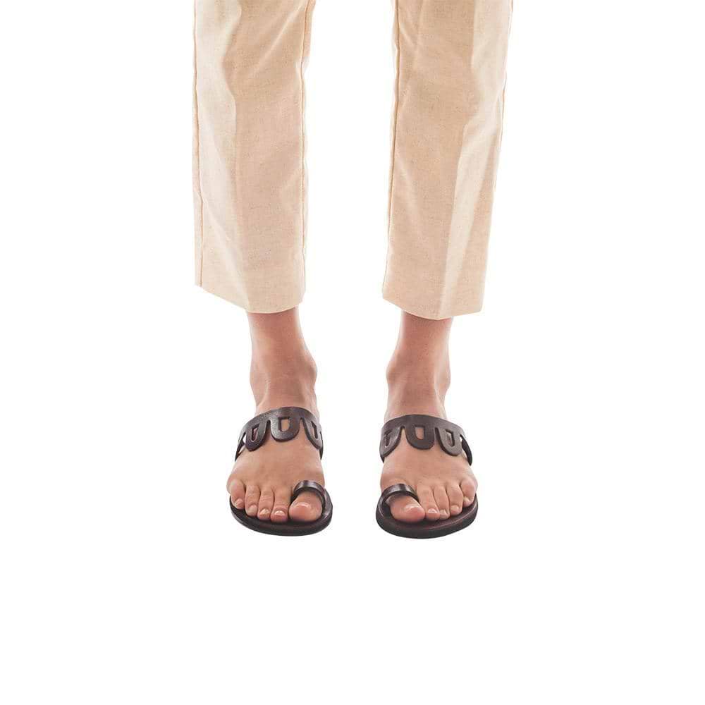 Model wearing Aja brown, handmade leather slide sandals with toe loop 
