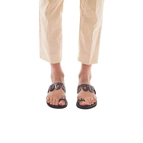 Model wearing Aja brown, handmade leather slide sandals with toe loop 