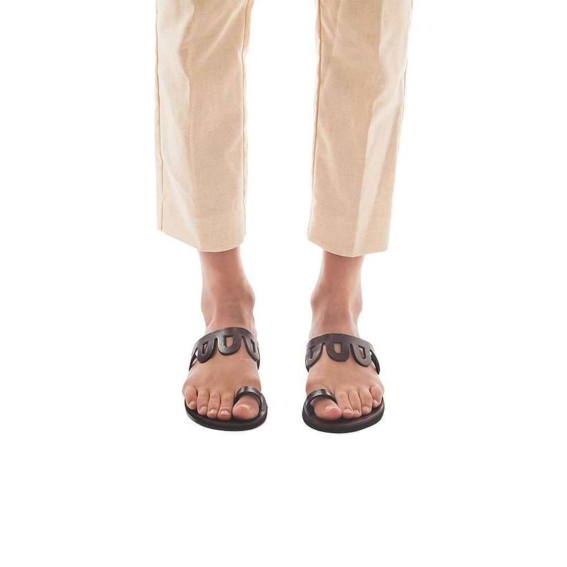 Model wearing Aja brown, handmade leather slide sandals with toe loop 