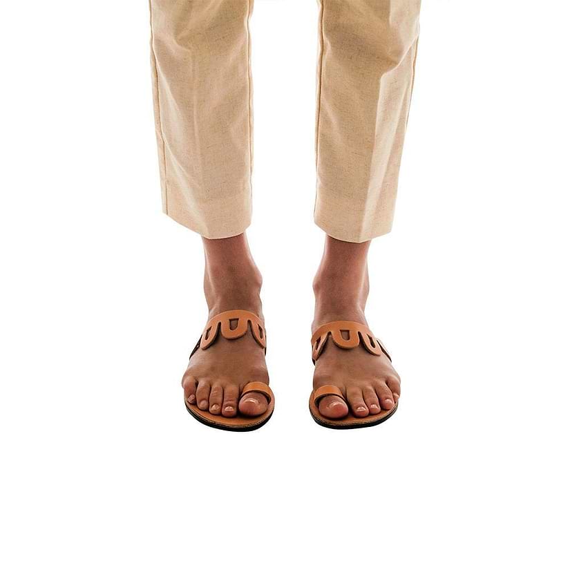 Model wearing Aja tan, handmade leather slide sandals with toe loop 