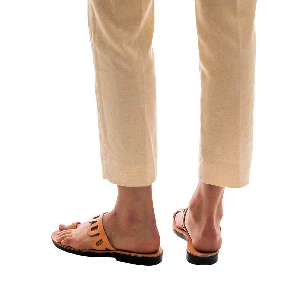 Model wearing Aja tan, handmade leather slide sandals with toe loop 