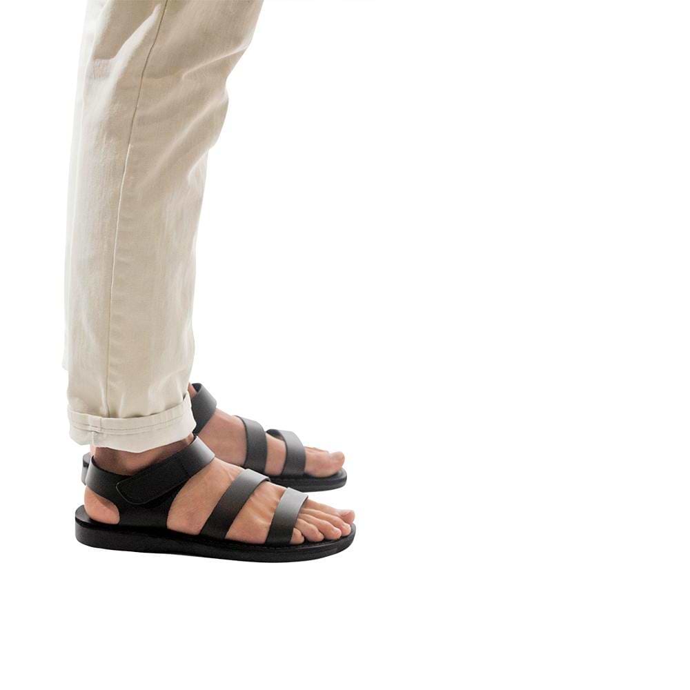 Model wearing Jared black, handmade leather sandals with back strap and toe loop