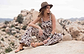 a female model with a hat sitting on a rock wearing Jerusalem sandals