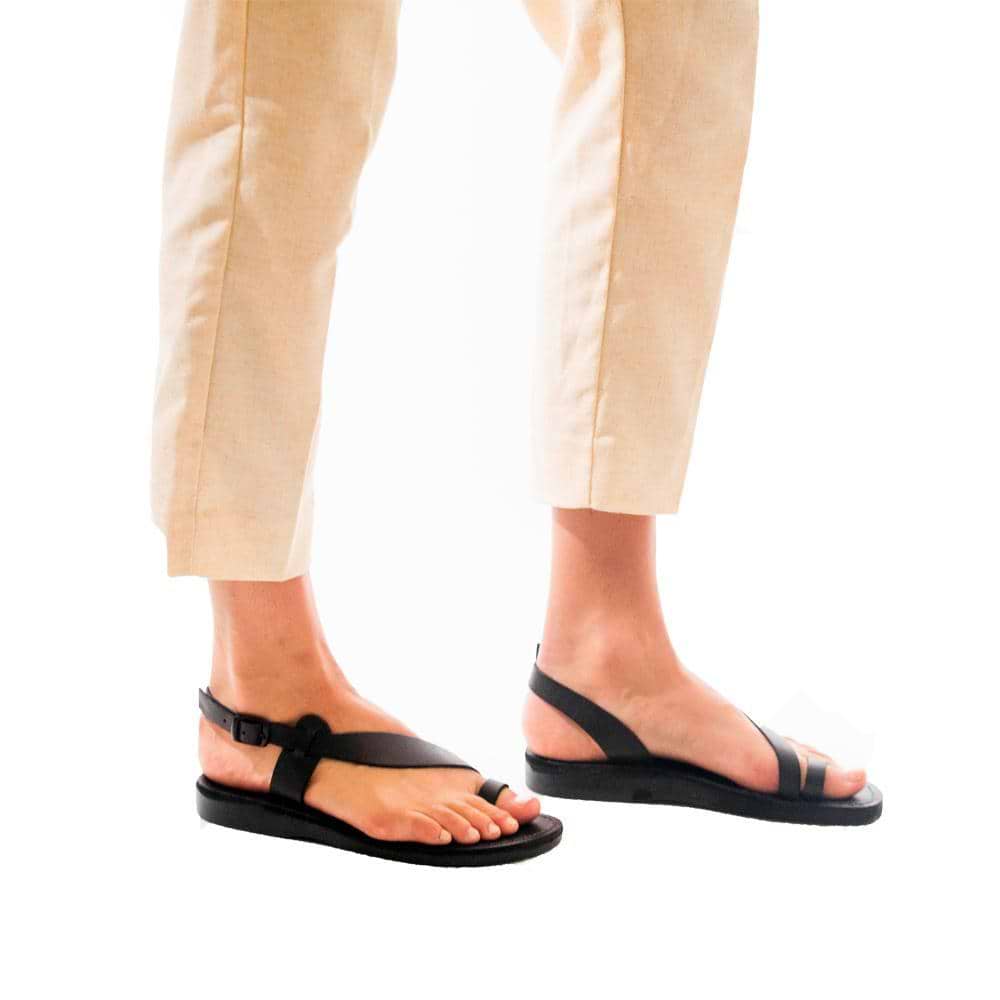 Model wearing Mia black, handmade leather sandals with back strap and toe loop  