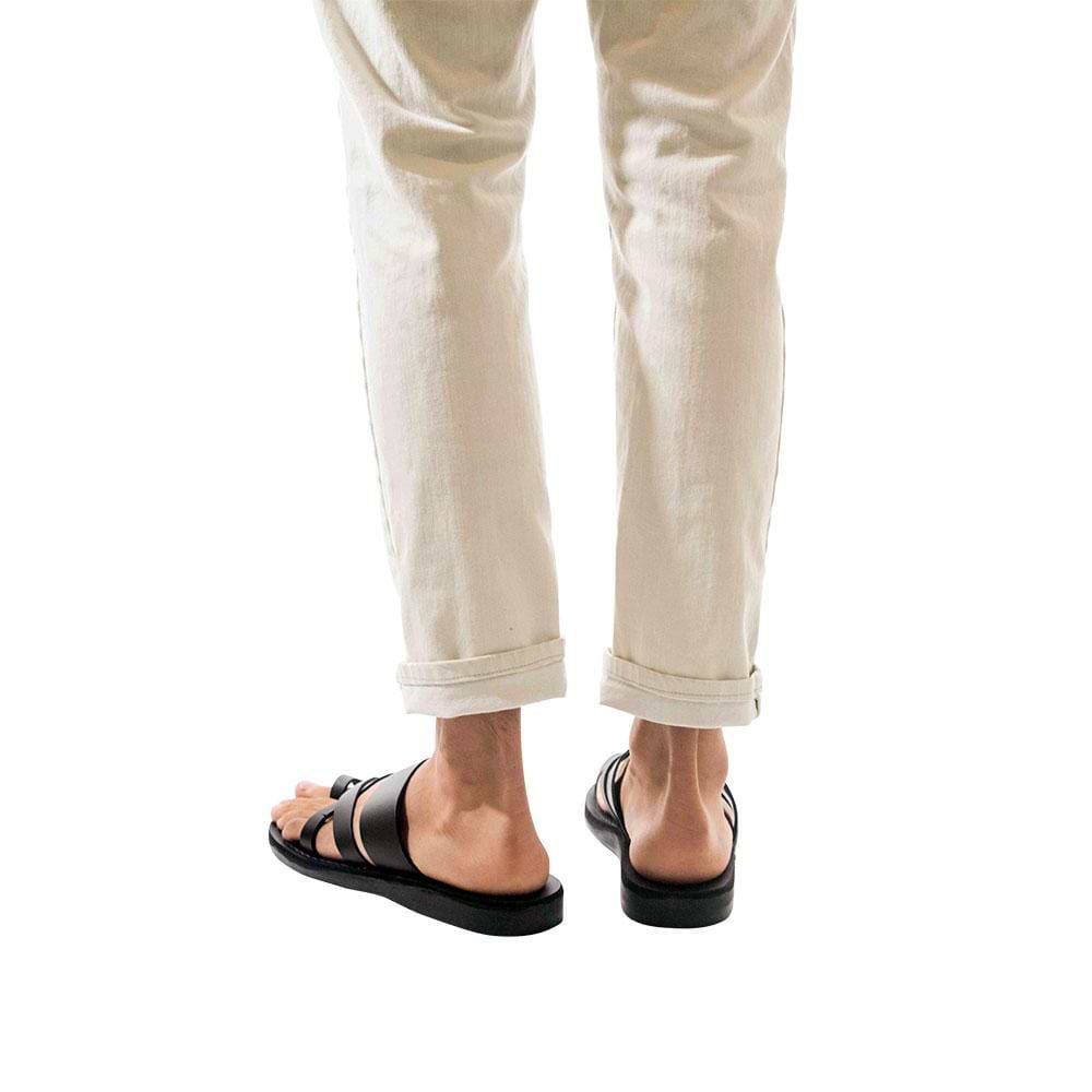 Model wearing The Good Shepherd black, handmade leather slide sandals with toe loop