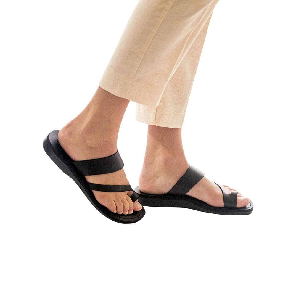 Model wearing Zohar black, handmade leather slide sandals with toe loop