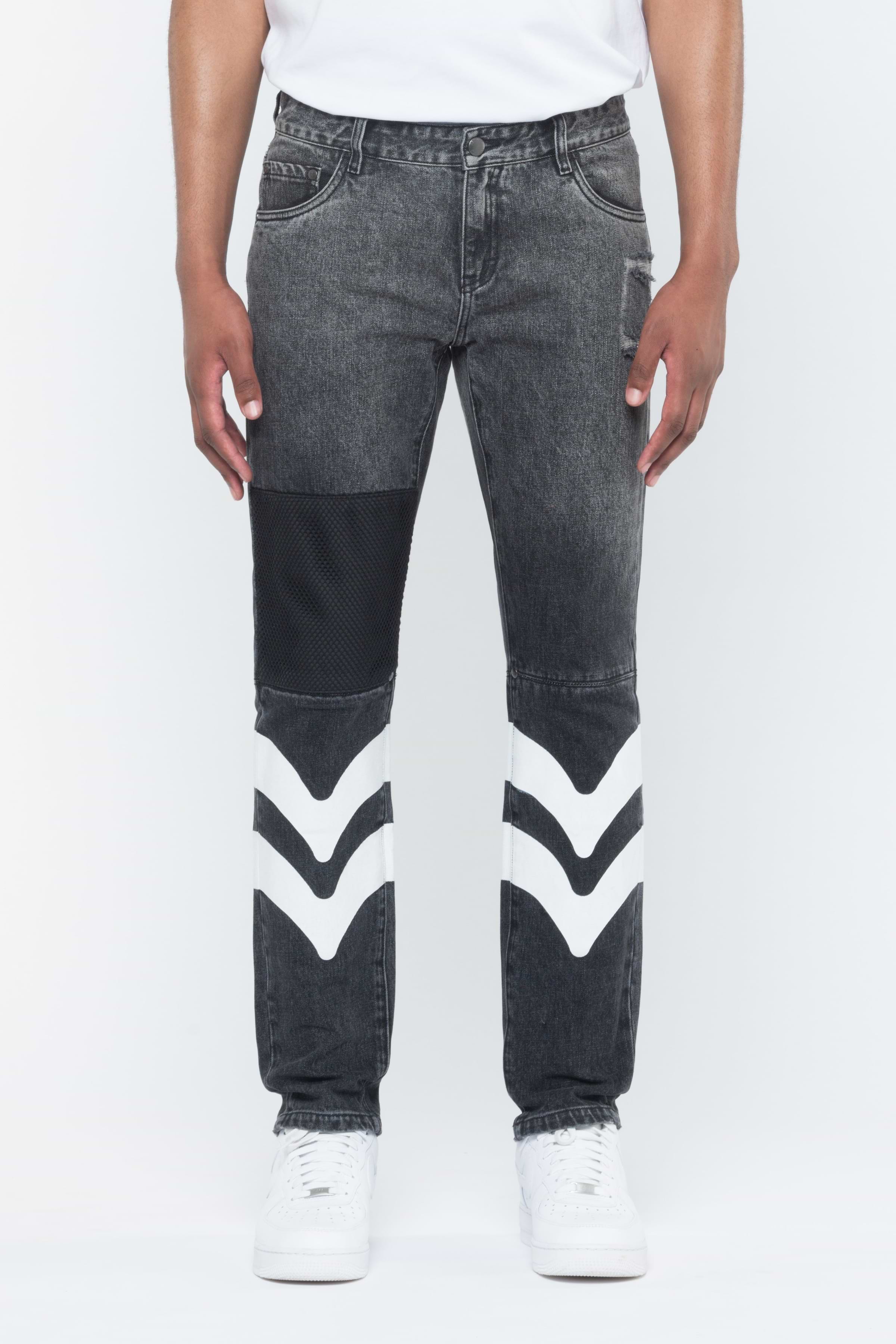 A pair of black denim pants with white leather patches on the leg, viewed from the side.