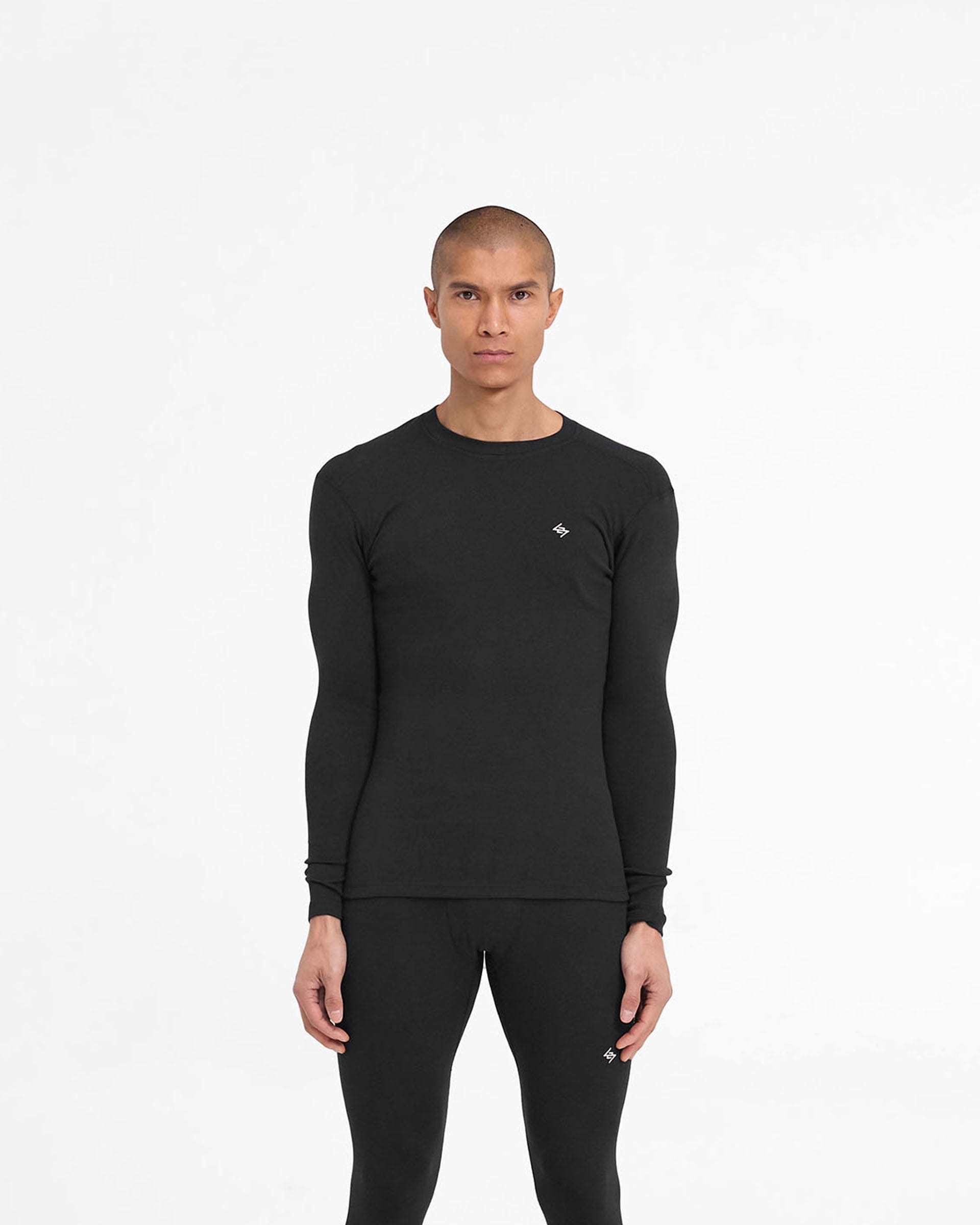 Man wearing a black ribbed long sleeve top on a plain white background | 247 Ribbed Long Sleeve Top in Black | Thermal base layer ribbed long sleeve top | 247 T-Shirts | Represent Clo