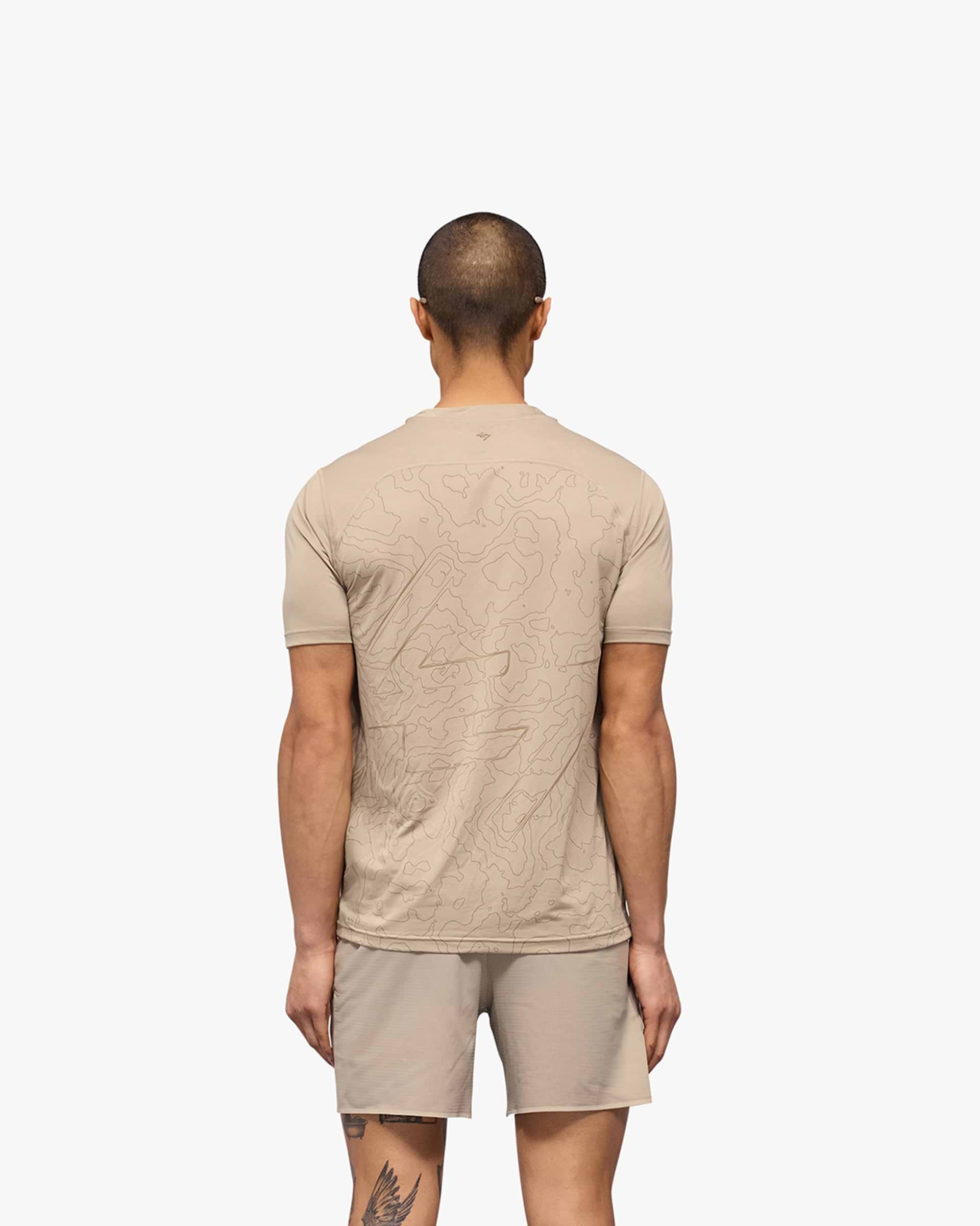 Man wearing a pebble grey running t-shirt on a plain white background | 247 Contour Run T-Shirt in Pebble | Breathable quick-dry running t-shirt with contour print | 247 T-Shirts | Represent Clo