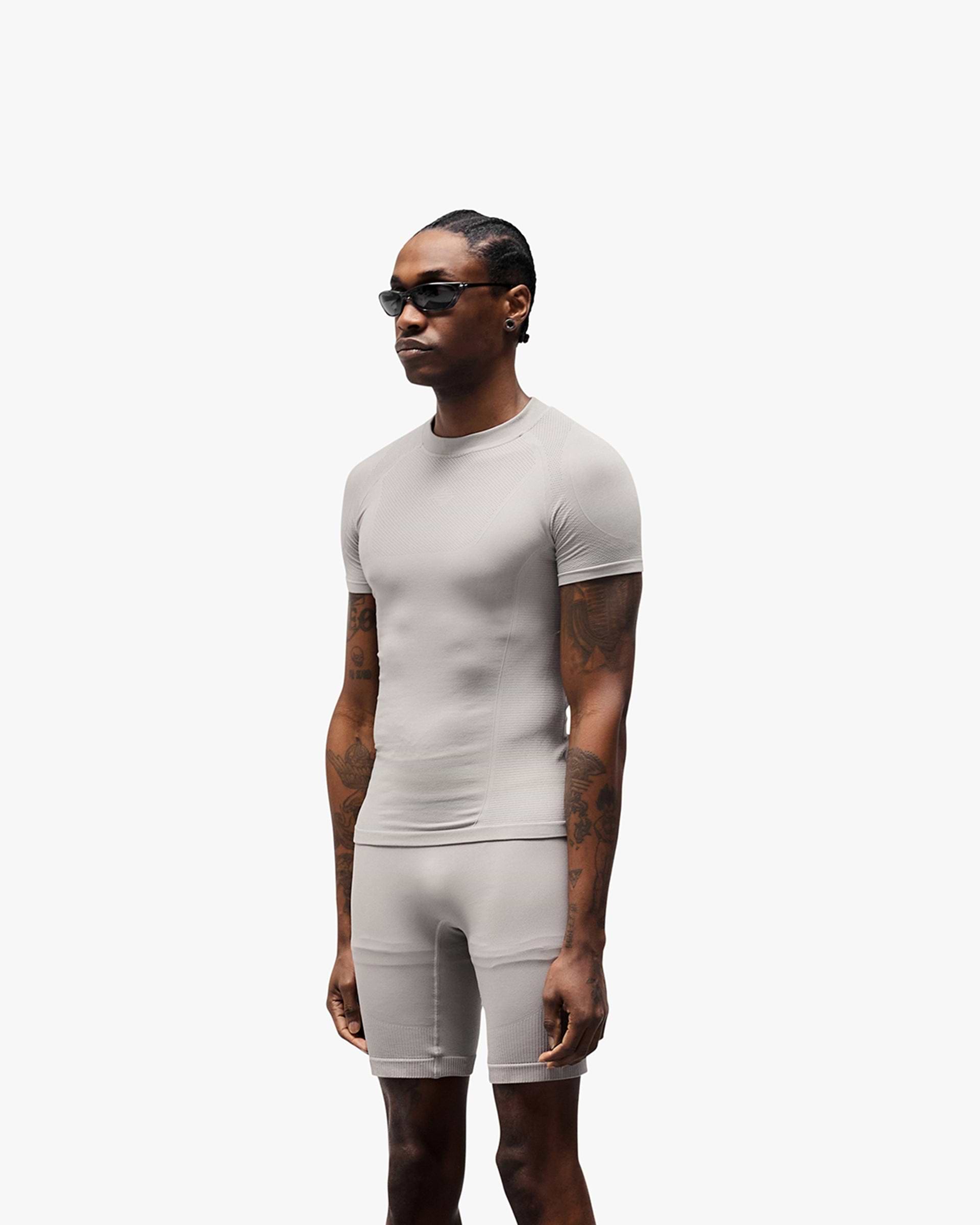 Man wearing a grey seamless t-shirt on a plain white background | 247 DNA Seamless T-Shirt in Titanium | Slim fit t-shirt with engineered knit zones | 247 T-Shirts | Represent Clo