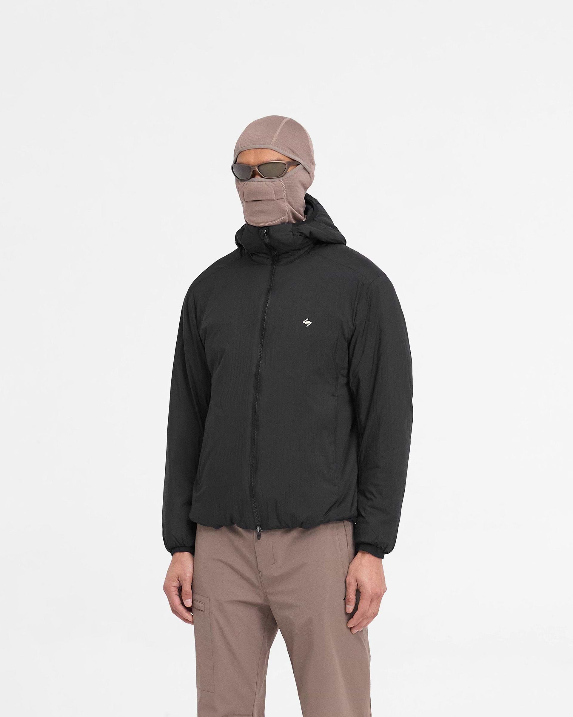 Man wearing a black insulated jacket on a plain white background | Team 247 Insulated Jacket in Black | Insulated jacket with DWR coating and adjustable features | 247 Outerwear | Represent Clo