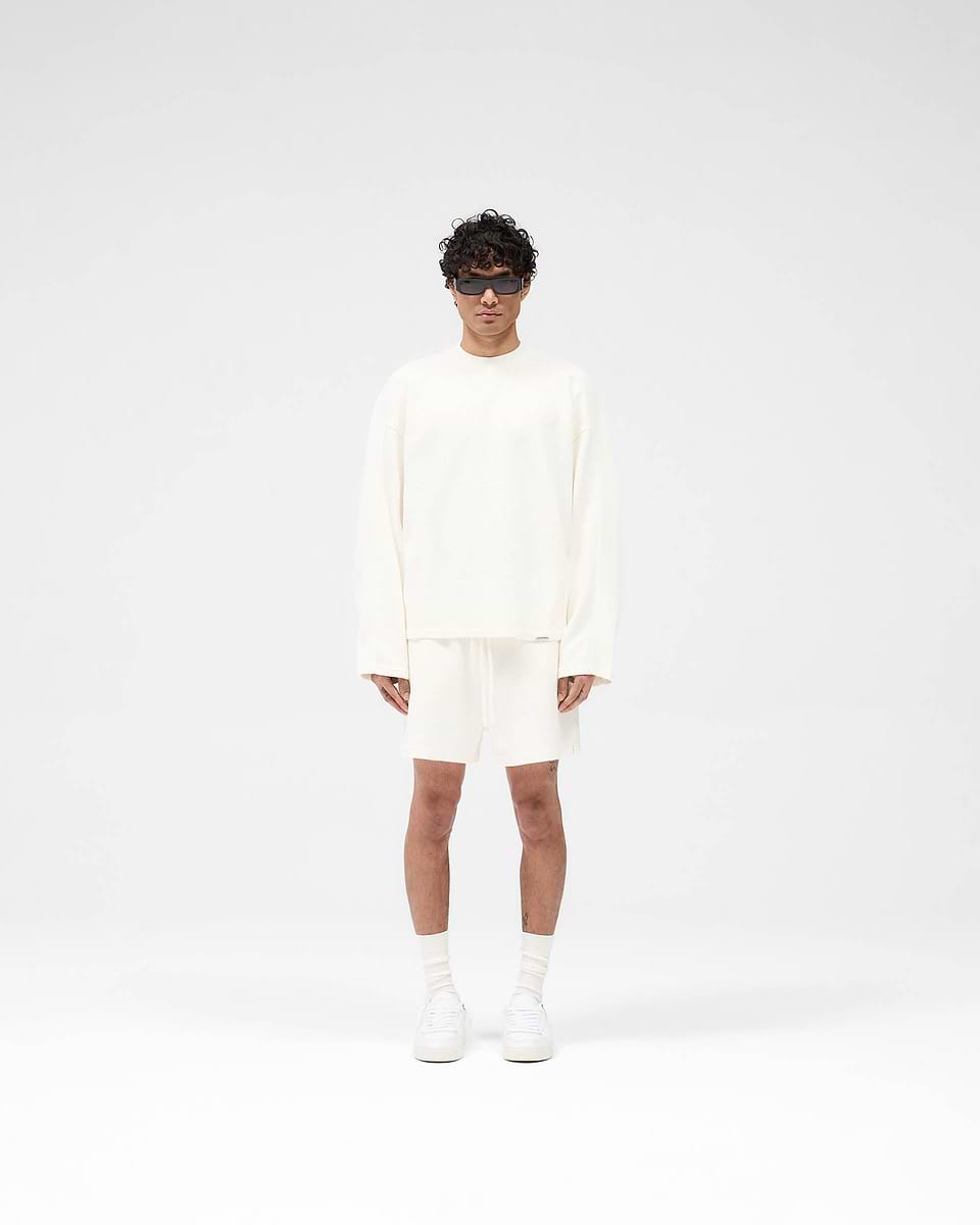 Man wearing a white long sleeve t-shirt on a plain white background | Waffle Long Sleeve T-Shirt in Flat White | Boxy fit t-shirt with waffle texture and metal logo bar | SS25 T-Shirts | Represent Clo