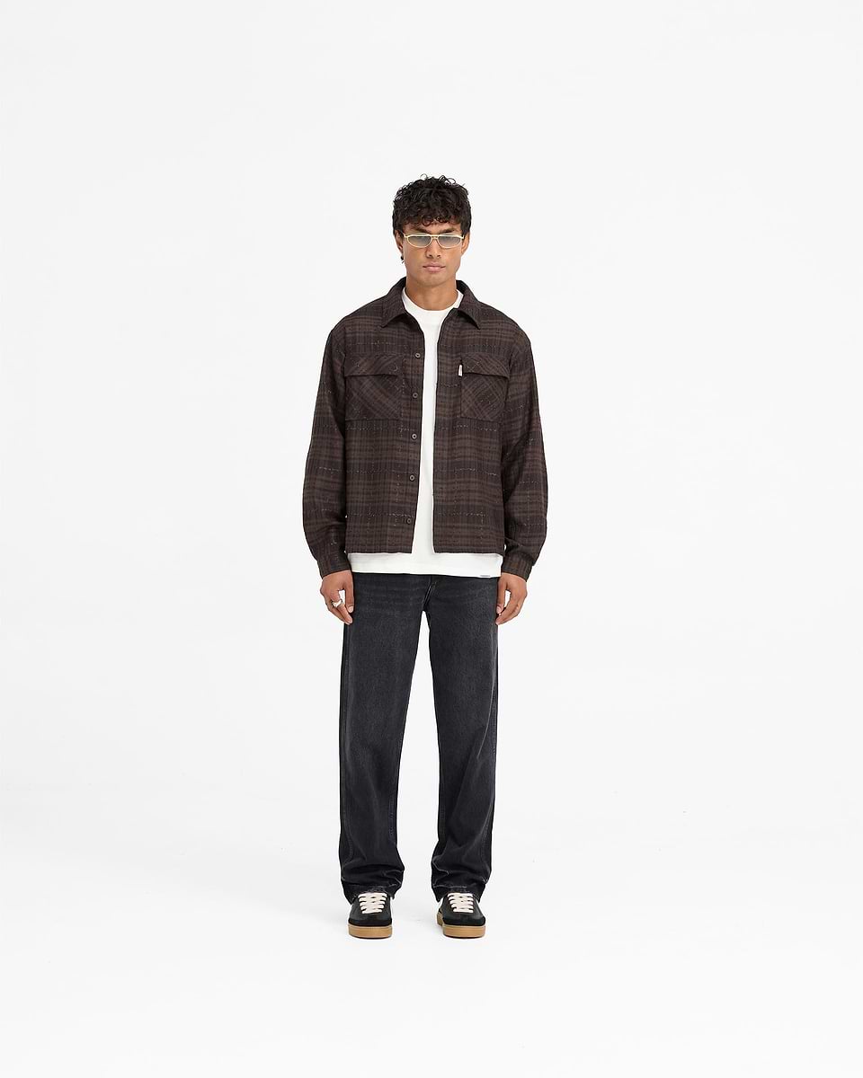 Man wearing a brown flannel shirt on a plain white background | Rep Flannel Shirt in Coffee | Slightly oversized flannel shirt with flap chest pockets | FW24 Shirts | Represent Clo