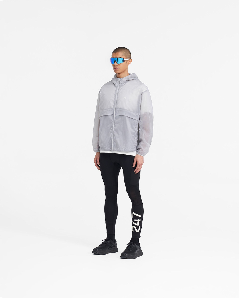 Man wearing a translucent moonstone jacket on a plain white background | 247 Hooded Training Jacket in Moonstone | Nylon ripstop jacket with DWR coating and adjustable hem | 247 Outerwear | Represent Clo