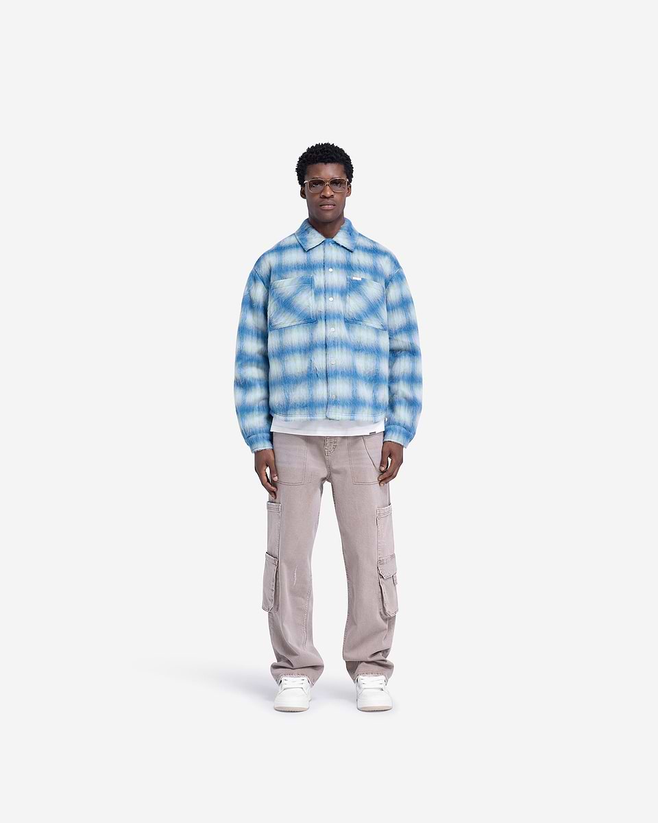 Man wearing an electric blue overshirt on a plain white background | Textured Overshirt in Electric Blue | Overshirt with patch pockets and popper closures | FW24 Shirts | Represent Clo