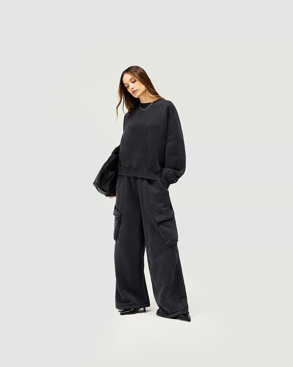 Woman wearing a black V notch sweater on a plain white background | Initial V Notch Sweater in Washed Black | Heavyweight cotton sweater with a relaxed fit | Womens Initial Sweaters | Represent Clo