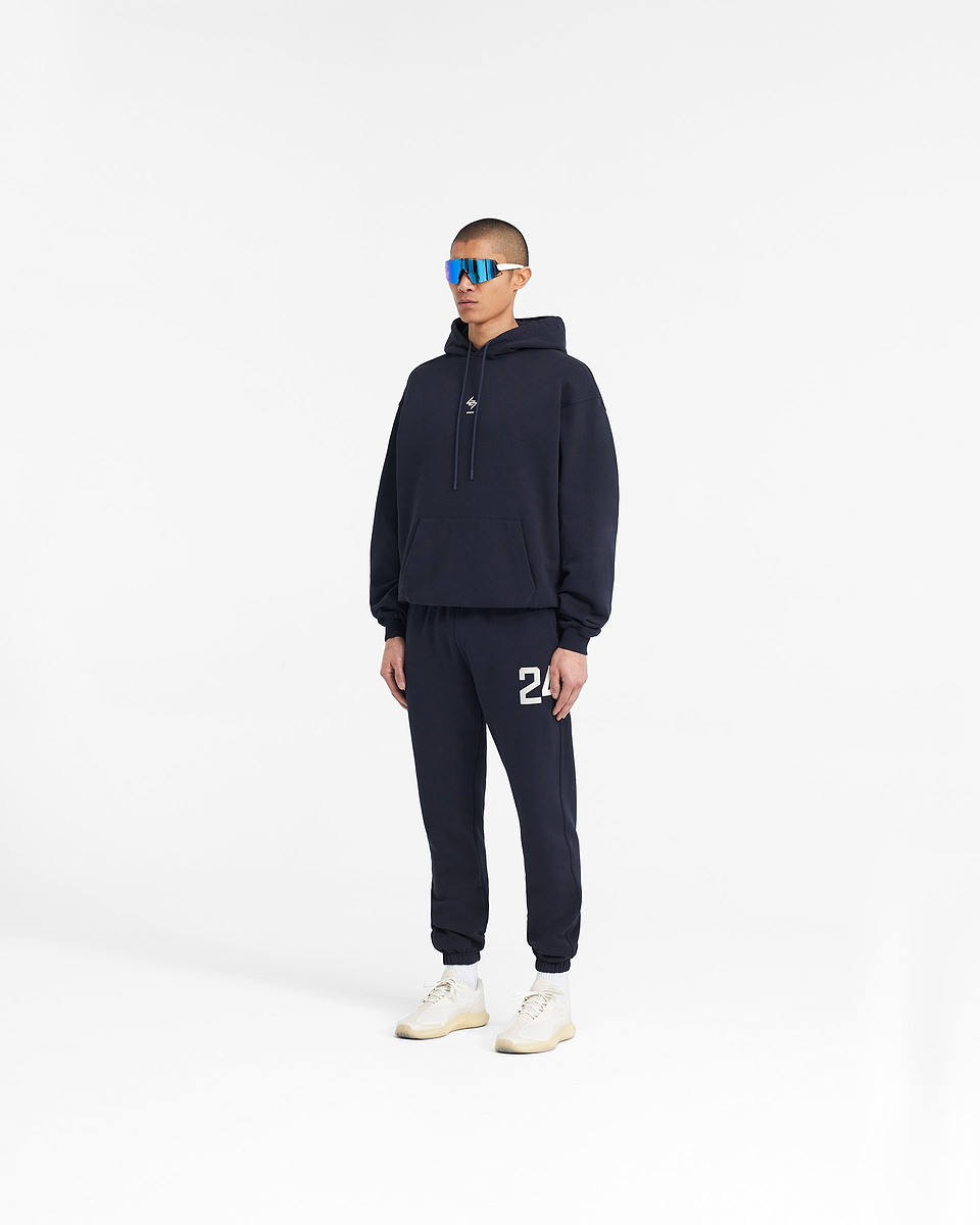 Man wearing navy sweatpants on a plain white background | 247 Sweatpants in Navy | Sweatpants with elasticated cuffs and drawcord waistband | 247 Pants | Represent Clo
