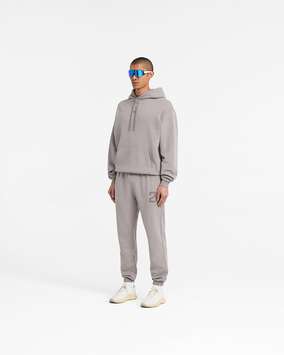 Man wearing grey sweatpants on a plain white background | 247 Sweatpant in Cinder | Training joggers with elasticated cuffs and drawcord waistband | 247 Pants | Represent Clo