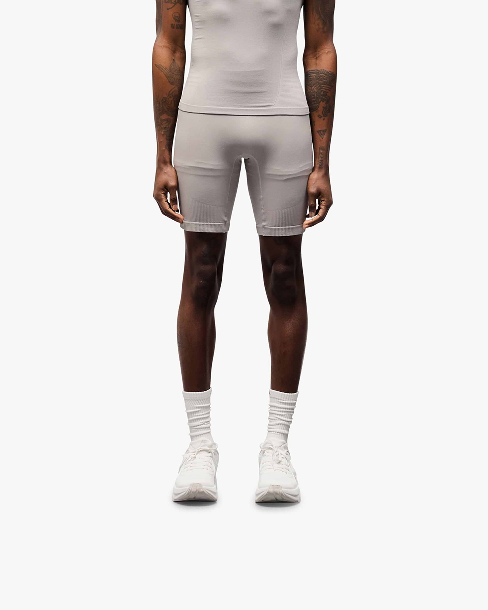 Man wearing grey seamless shorts on a plain white background | 247 DNA Seamless Shorts in Titanium | Seamless half tight with knit structured panels | 247 Shorts | Represent Clo