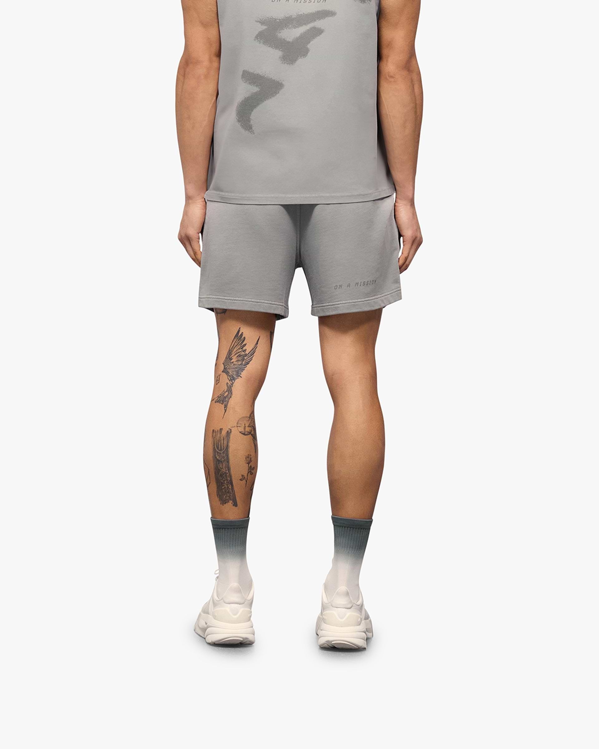 Man wearing grey shorts on a plain white background | 247 Motion Shorts in Titanium | Jersey shorts with elasticated waistband | 247 Shorts | Represent Clo