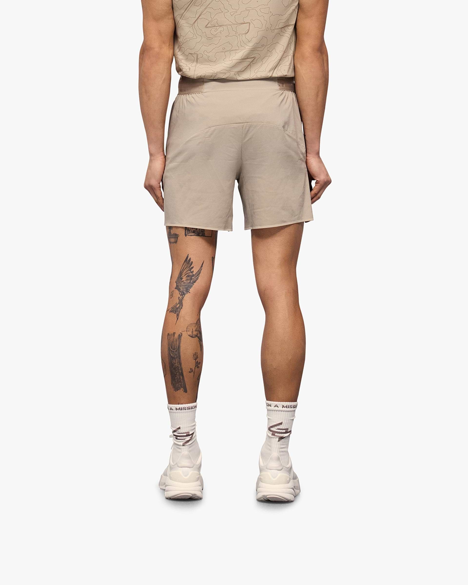 Man wearing grey shorts on a plain white background | Team 247 Aero Shorts in Pebble | Lightweight breathable running shorts | 247 Shorts | Represent Clo