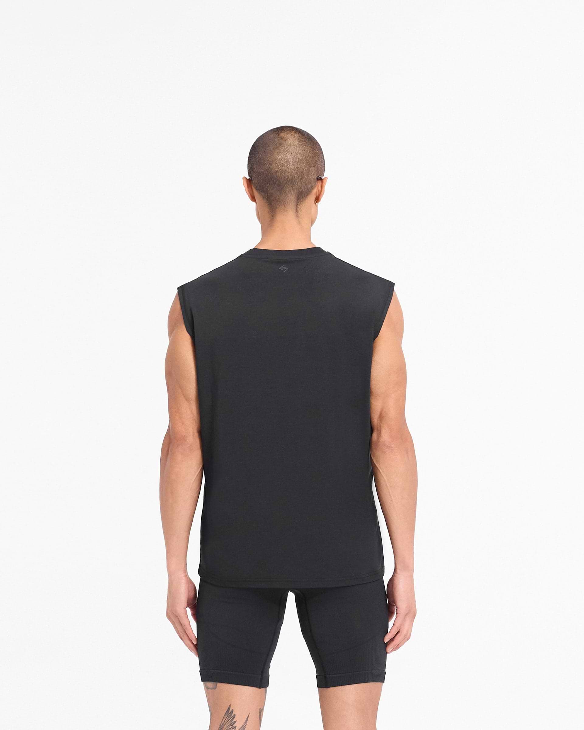 Man wearing a black gym tank top on a plain white background | 247 DNA Oversized Tank in Black | Quick drying lightweight oversized tank | 247 T-Shirts | Represent Clo