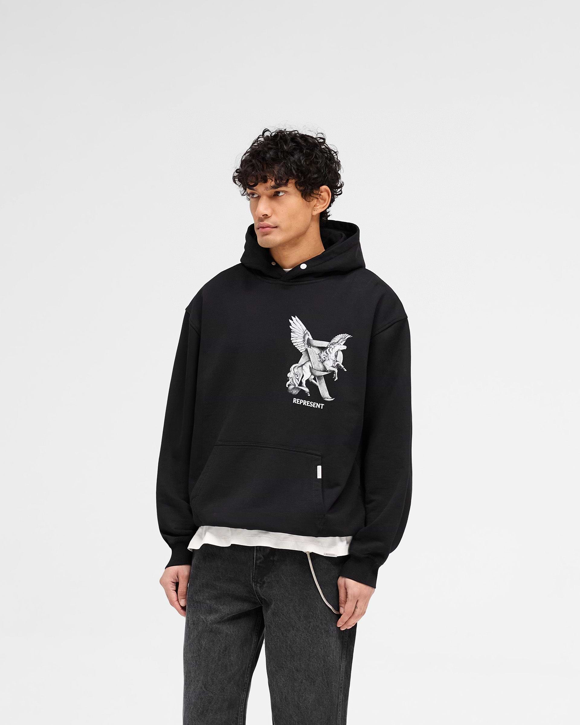 Man wearing a black hoodie on a plain white background | Elegance In Motion Hoodie in Jet Black | Oversized hoodie with motion graphic and popper fastening | SS25 Hoodies | Represent Clo