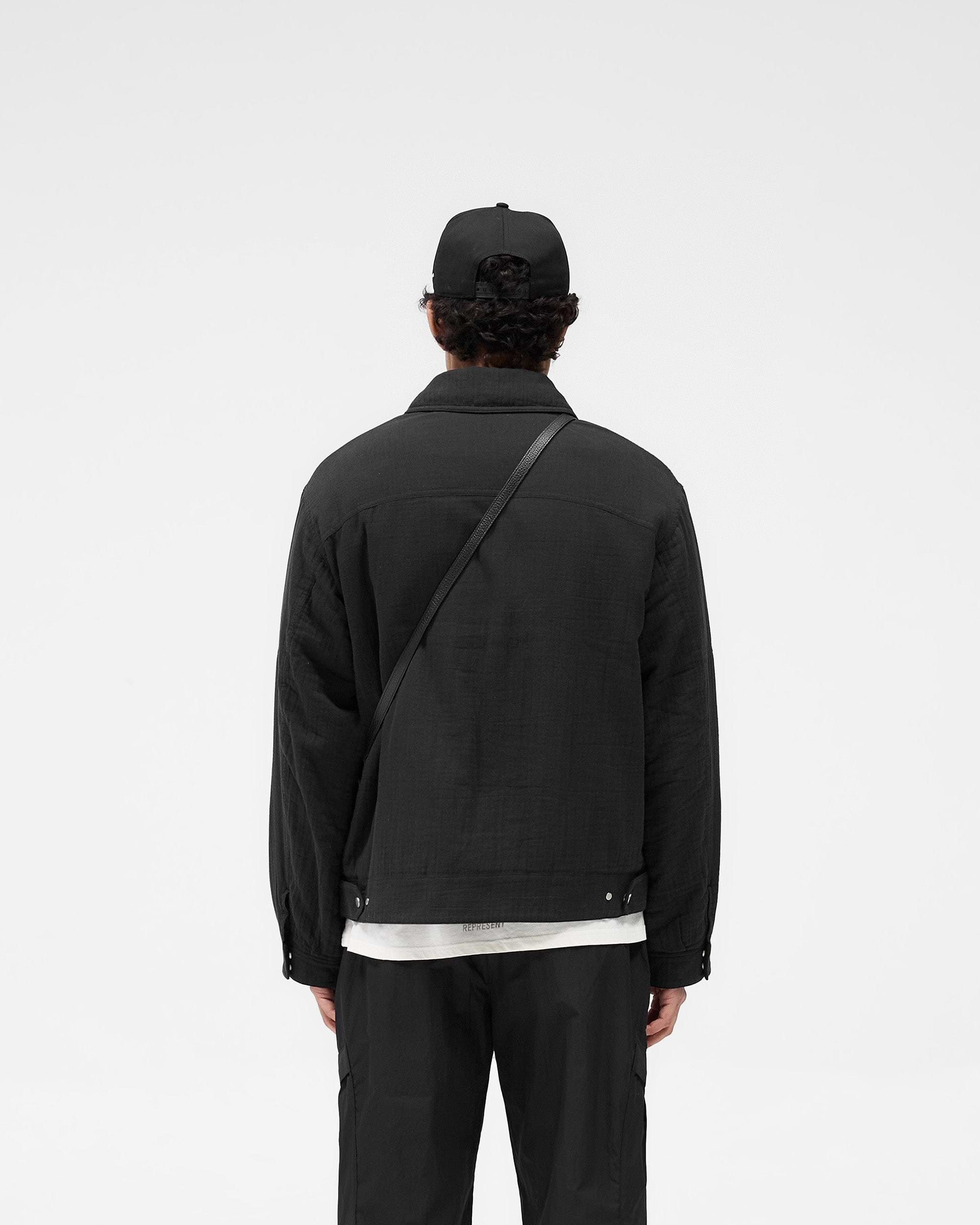 Man wearing a black crinkle trucker jacket on a plain white background | Crinkle Trucker Jacket in Black | Textured cotton oversized jacket with zip and pockets | SS25 Outerwear | Represent Clo