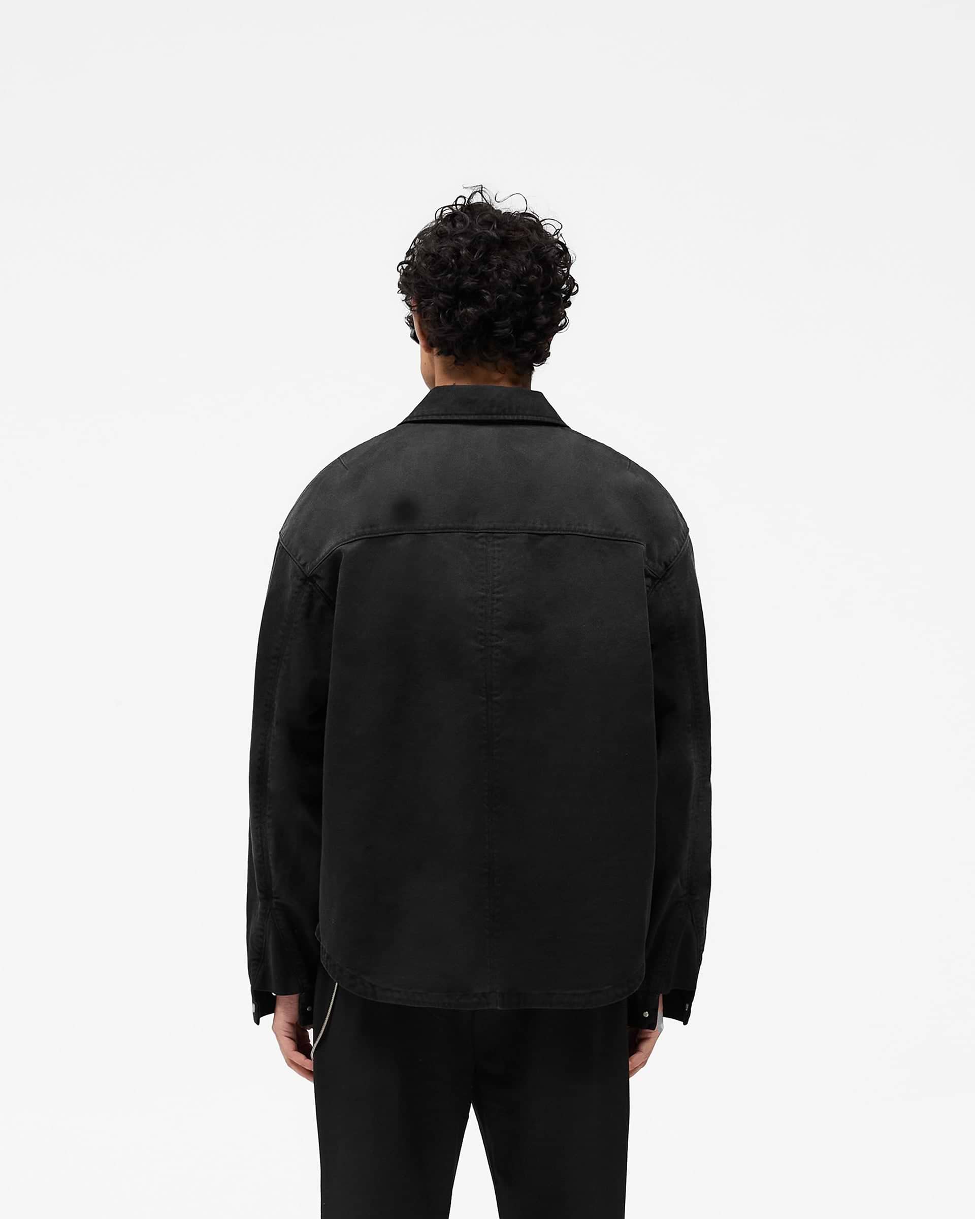 Man wearing a black zip through shirt on a plain white background | Cotton Zip Through Shirt in Black | Shirt with double zips and chest pocket | SS25 Shirts | Represent Clo