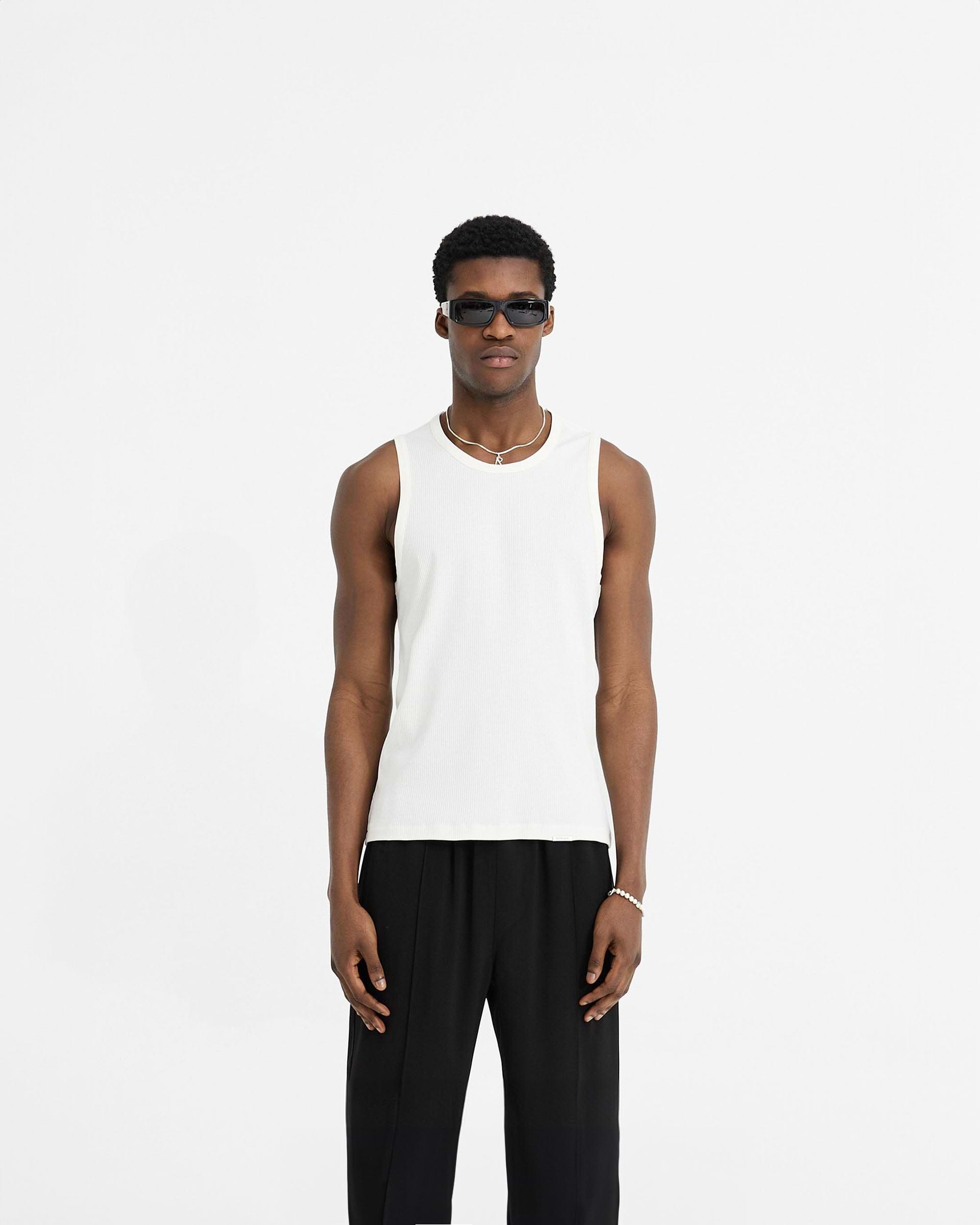 Man wearing a white rib vest on a plain white background | Initial Rib Vest in Flat White | Lightweight soft rib t-shirt with embroidered initial | Initial T-Shirts | Represent Clo
