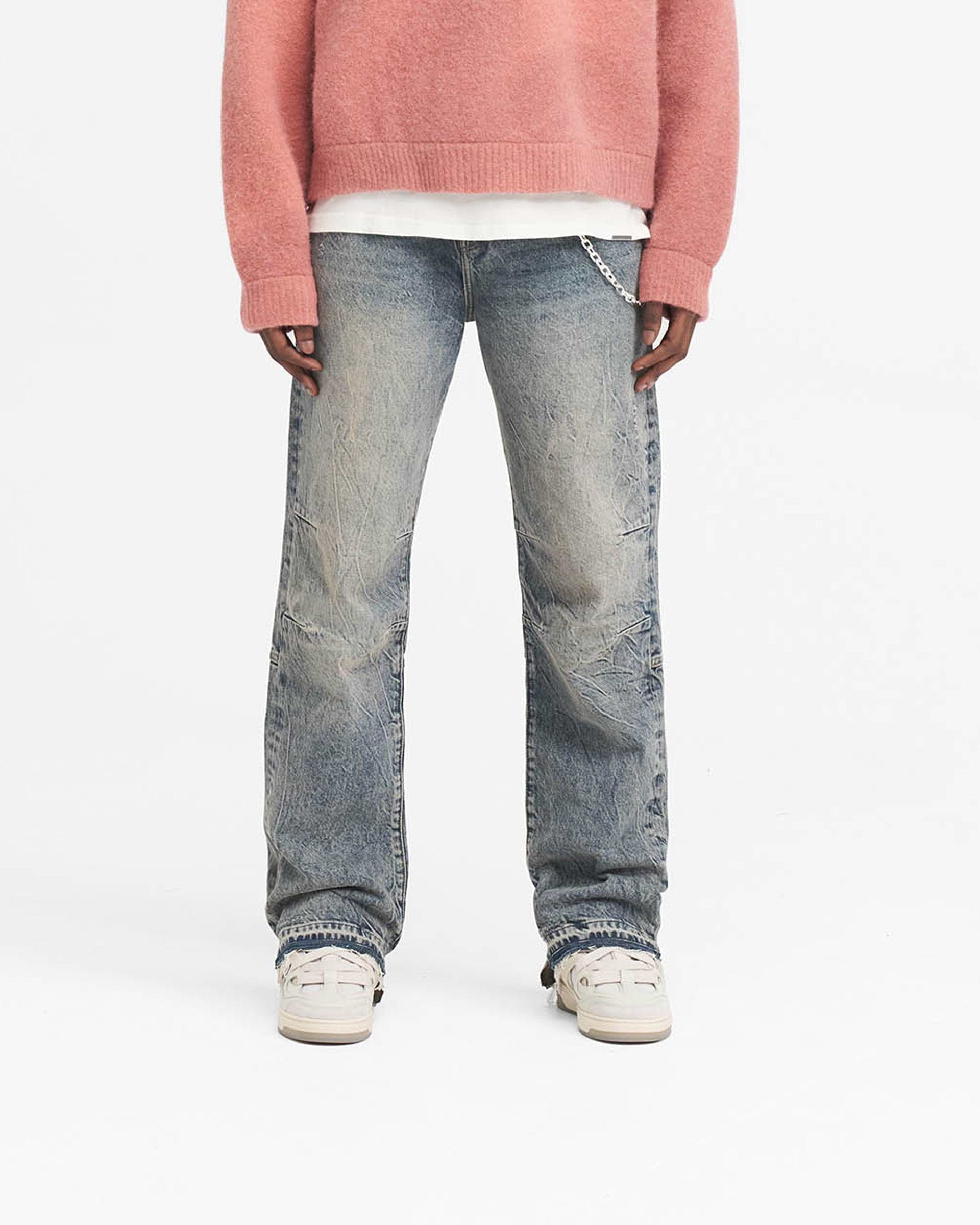 Man wearing mid blue denim on a plain white background | R2 Stepped Hem Denim in Mid Blue | Straight leg jeans with stepped hem and whiskering details | SS24 Denim | Represent Clo