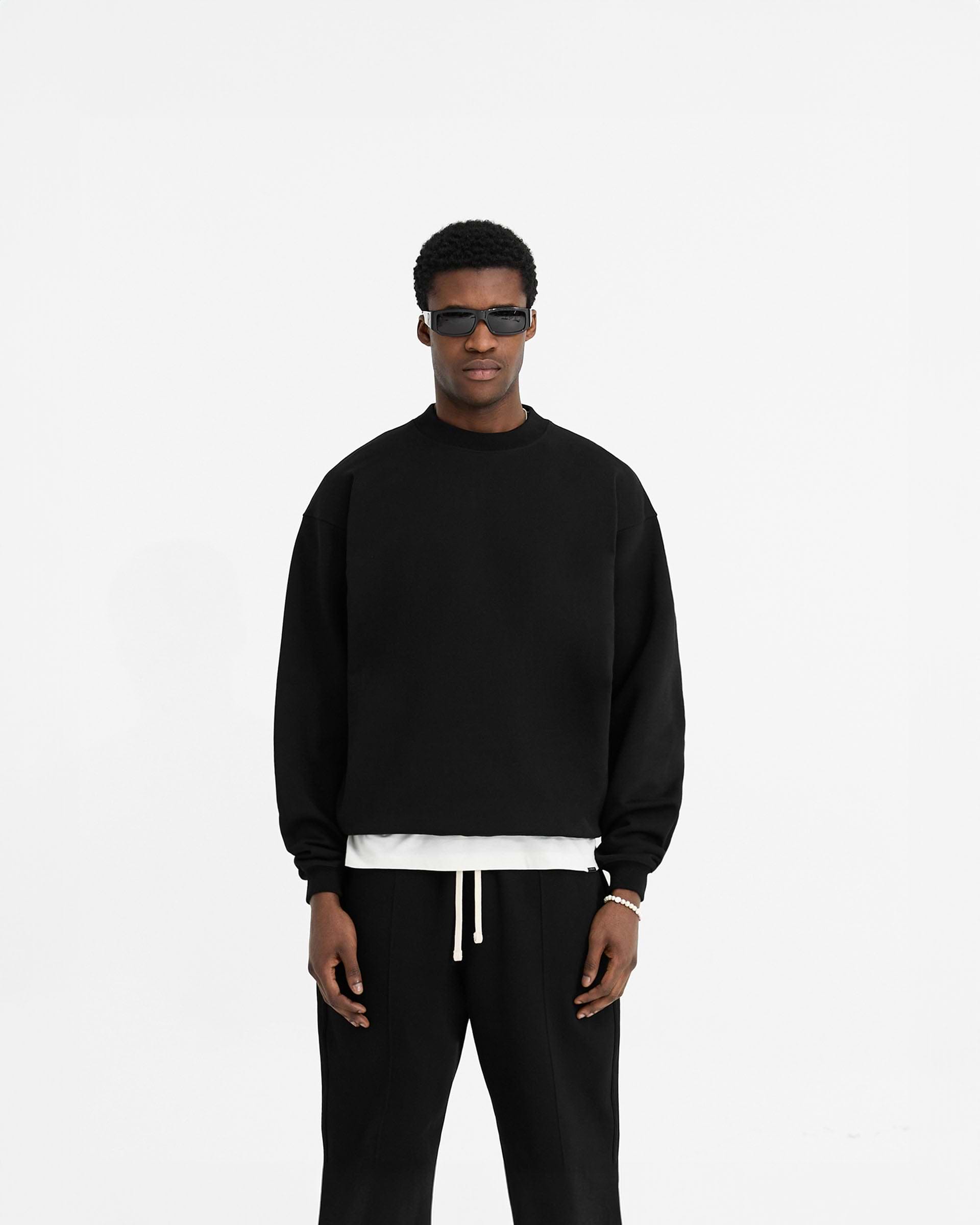 Man wearing a black oversized sweater on a plain white background | Initial Oversized Sweater in Black | Heavyweight loopback jersey organic cotton sweater | Initial Sweaters | Represent Clo