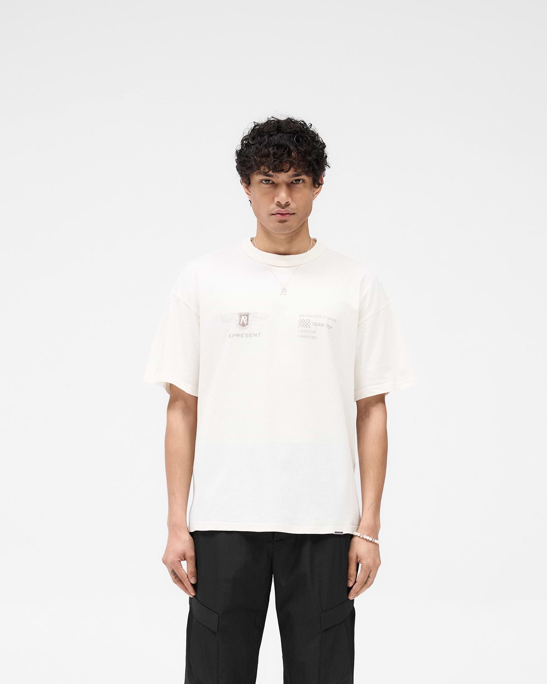 Man wearing an oversized white t-shirt on a plain white background | Team Rep T-Shirt in Flat White | Slub jersey oversized t-shirt with bound neckline | SS25 T-Shirts | Represent Clo