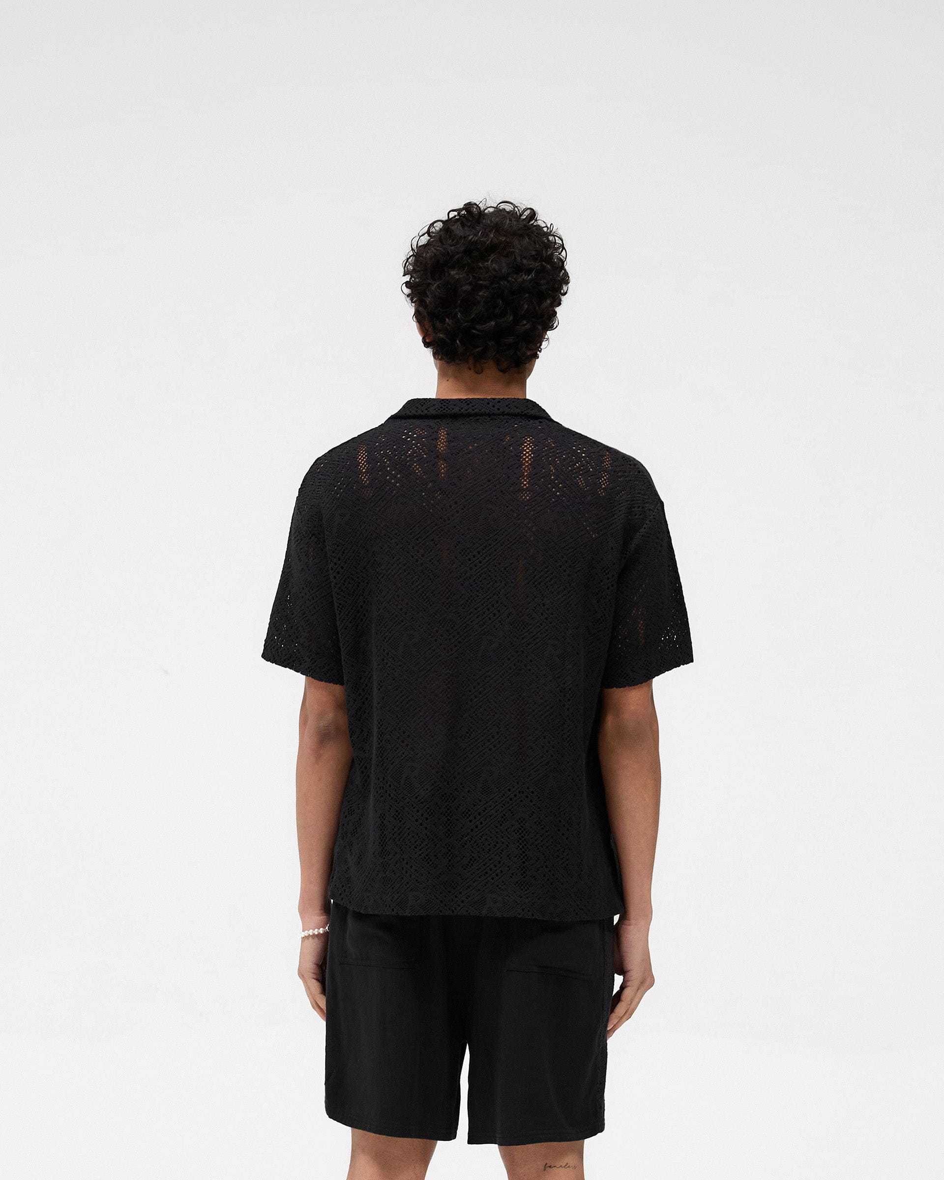 Man wearing a black crochet shirt on a plain white background | All Over Crochet Shirt in Jet Black | Oversized fit crochet shirt with camp collar | SS25 Knitwear | Represent Clo