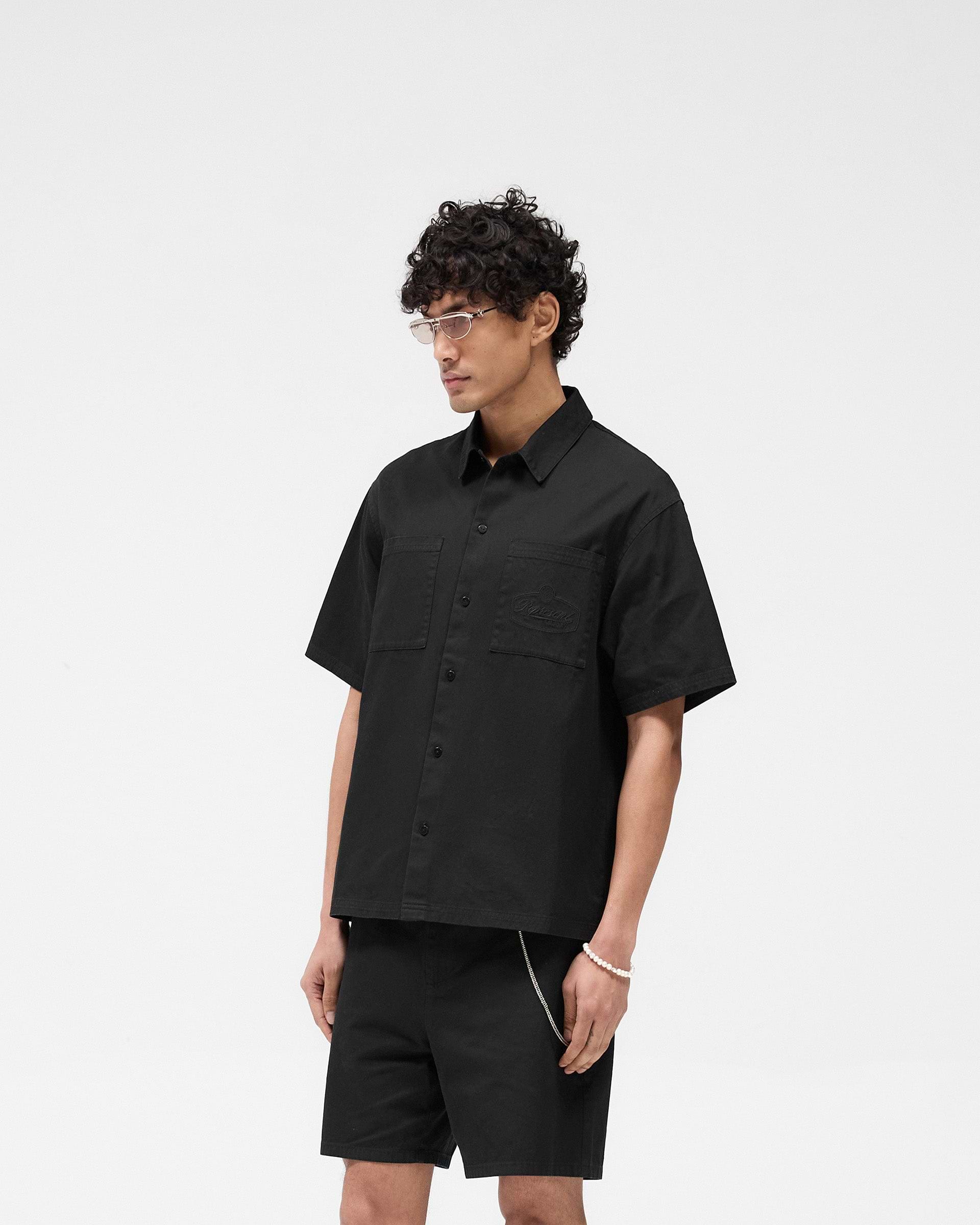 Back product image of a mens black shirt on a plain white background | Short Sleeve Cotton Overshirt in Washed Black | Overshirt with dual chest pockets | SS25 Shirts | Represent Clo