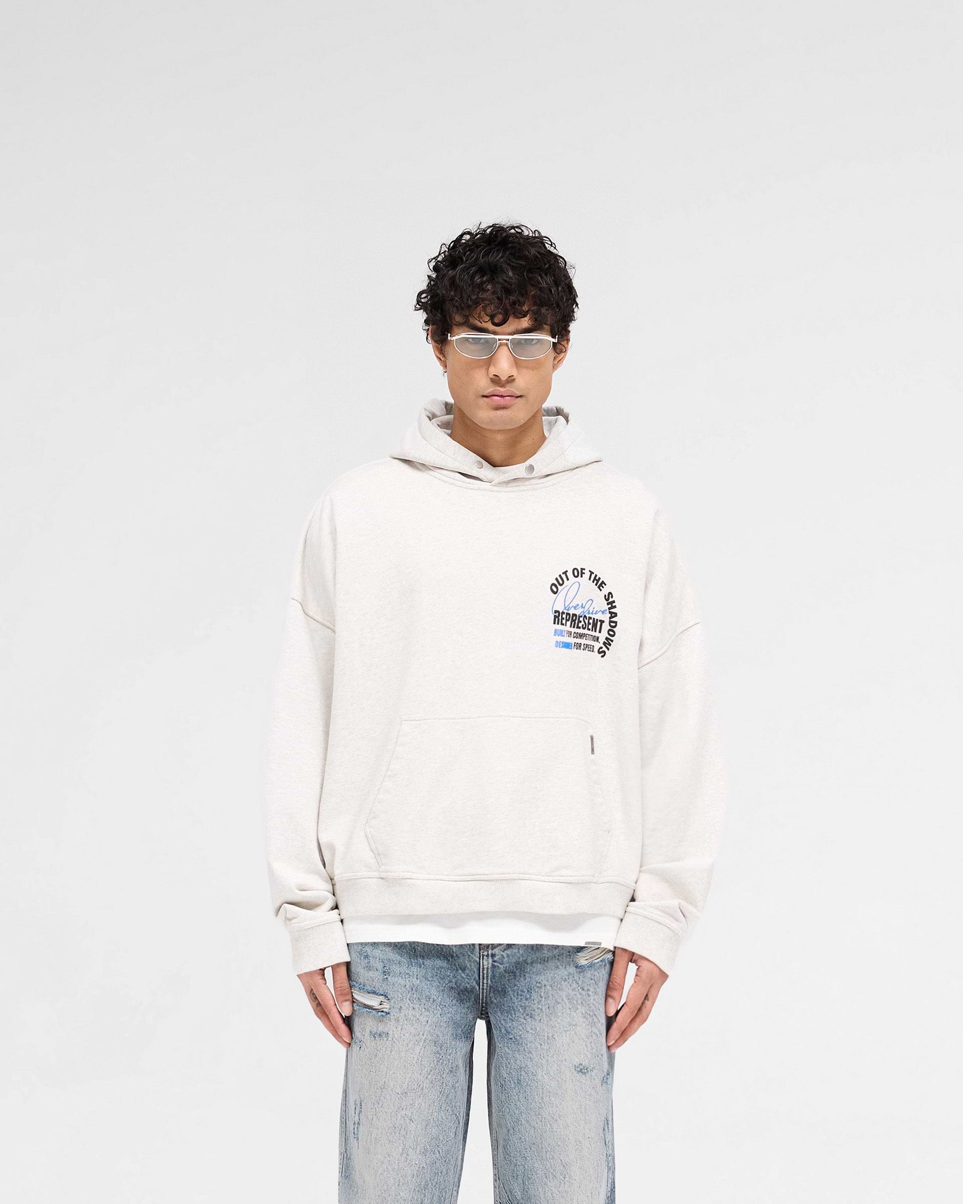Man wearing a cream hoodie on a plain white background | Out Of The Shadows Hoodie in Cream Marl | Oversized boxy fit heavyweight hoodie | SS25 Hoodies | Represent Clo