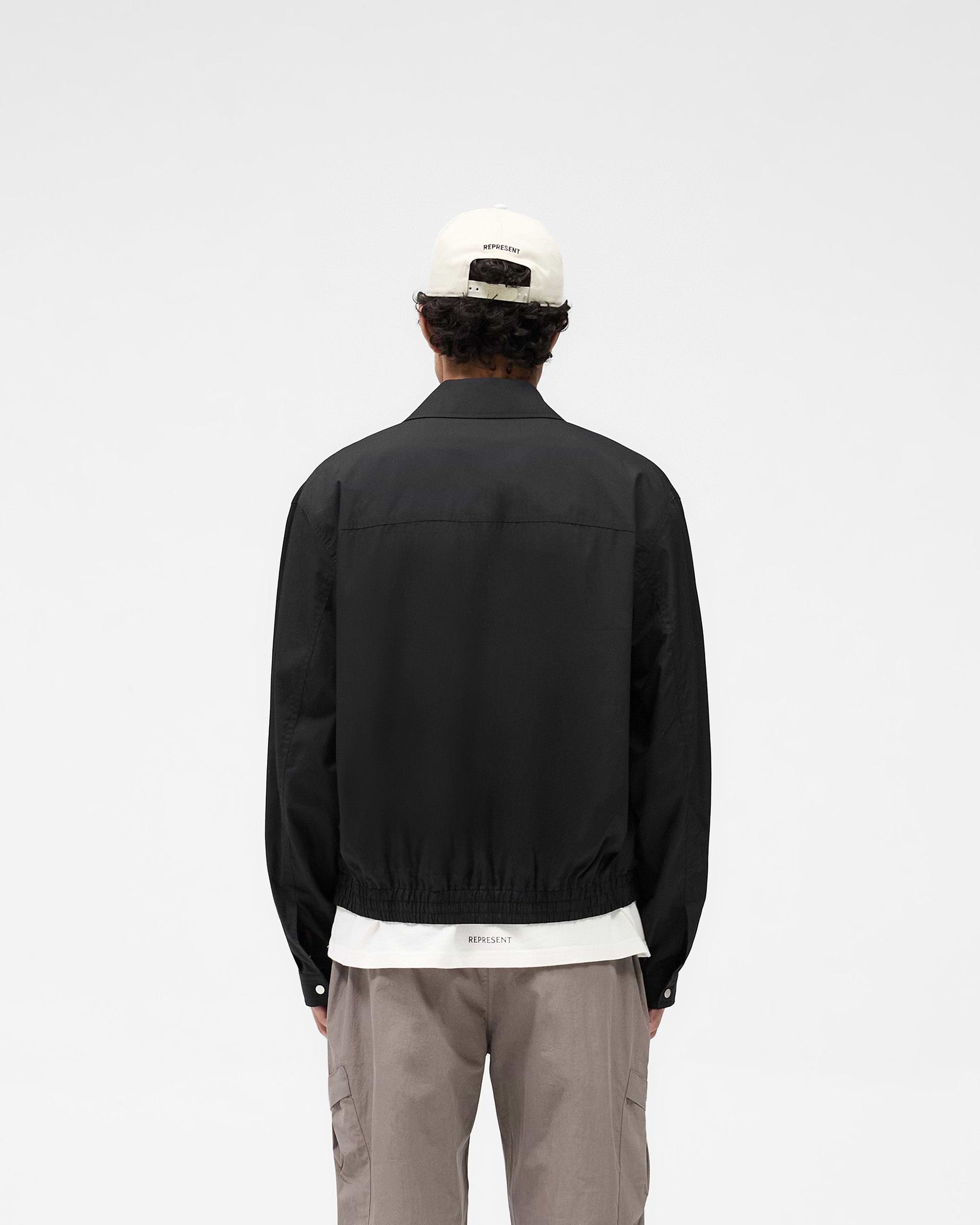 Man wearing a black shirt bomber on a plain white background | Shirt Bomber in Black | Lightweight bomber-inspired fit with welt pockets | SS25 Shirts | Represent Clo