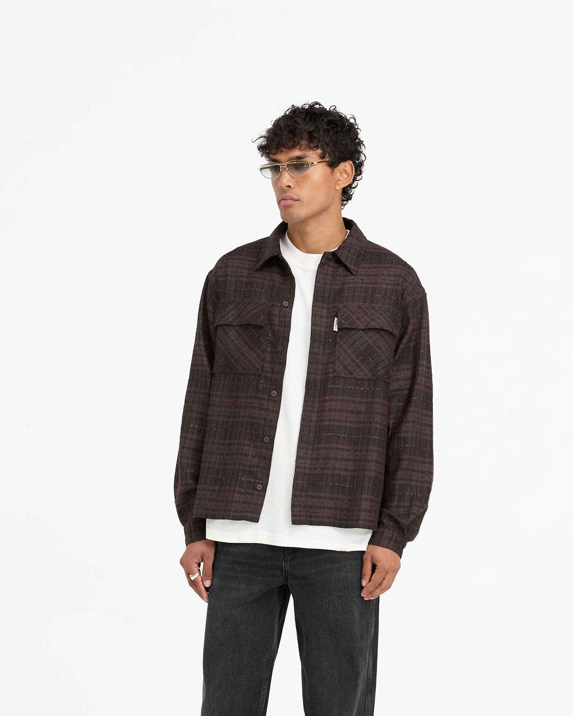 Man wearing a brown flannel shirt on a plain white background | Rep Flannel Shirt in Coffee | Oversized shirt with flap chest pockets | FW24 Shirts | Represent Clo
