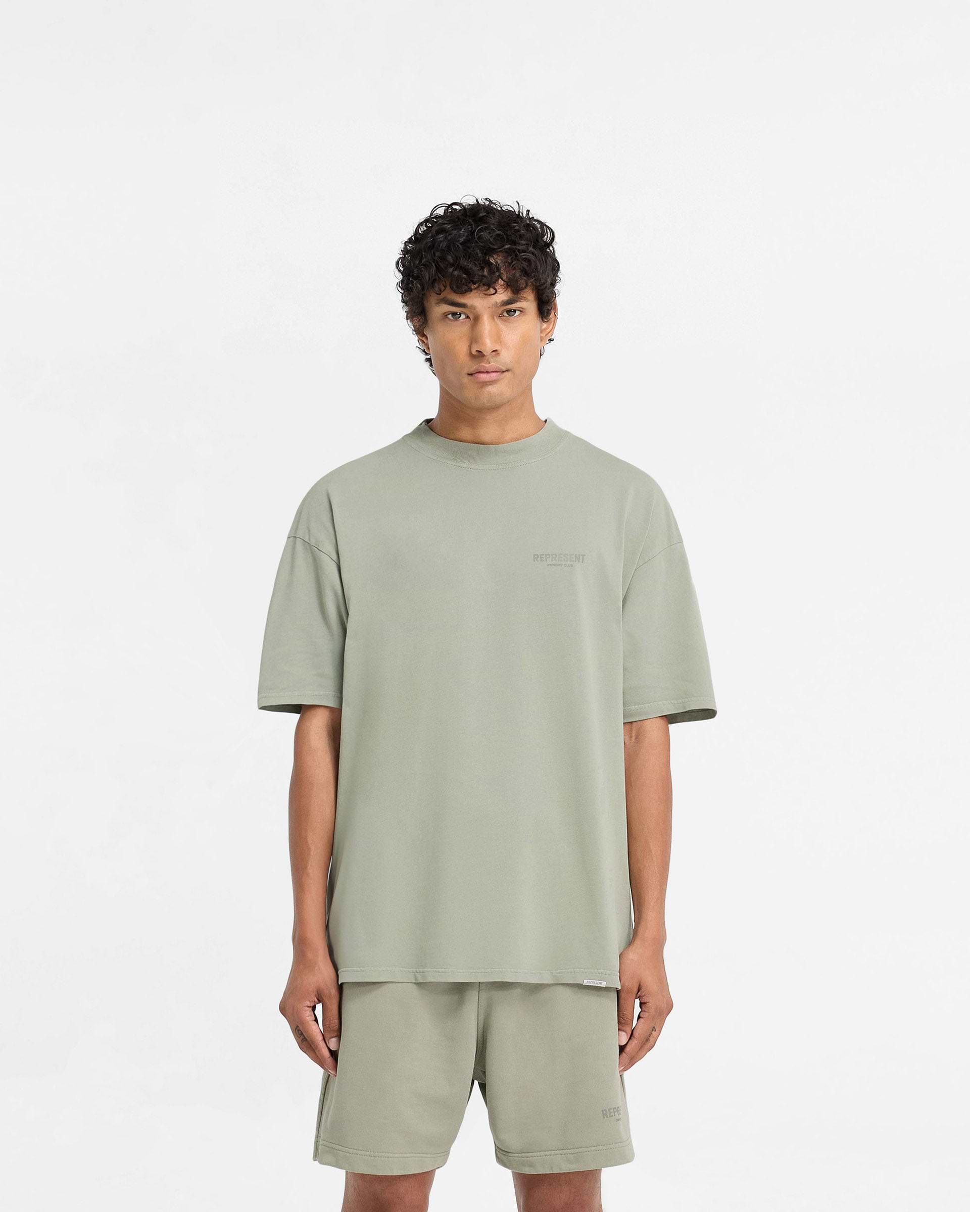 Man wearing an oversized pastel green t-shirt on a plain white background | Represent Owners Club T-Shirt in Pastel Green | Jersey t-shirt with ribbed crewneck collar | Owners Club T-Shirts | Represent Clo