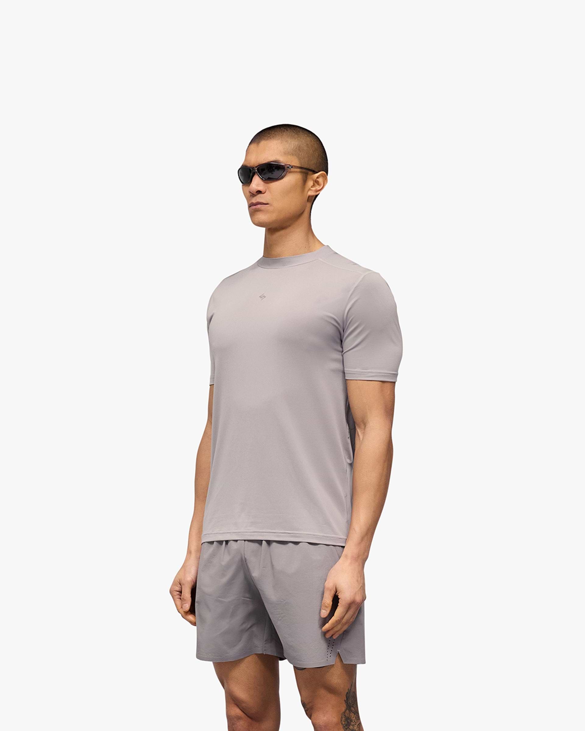 Man wearing a titanium running t-shirt on a plain white background | 247 Contour Run T-Shirt in Titanium | Breathable mesh running t-shirt with contour back print | 247 T-Shirts | Represent Clo
