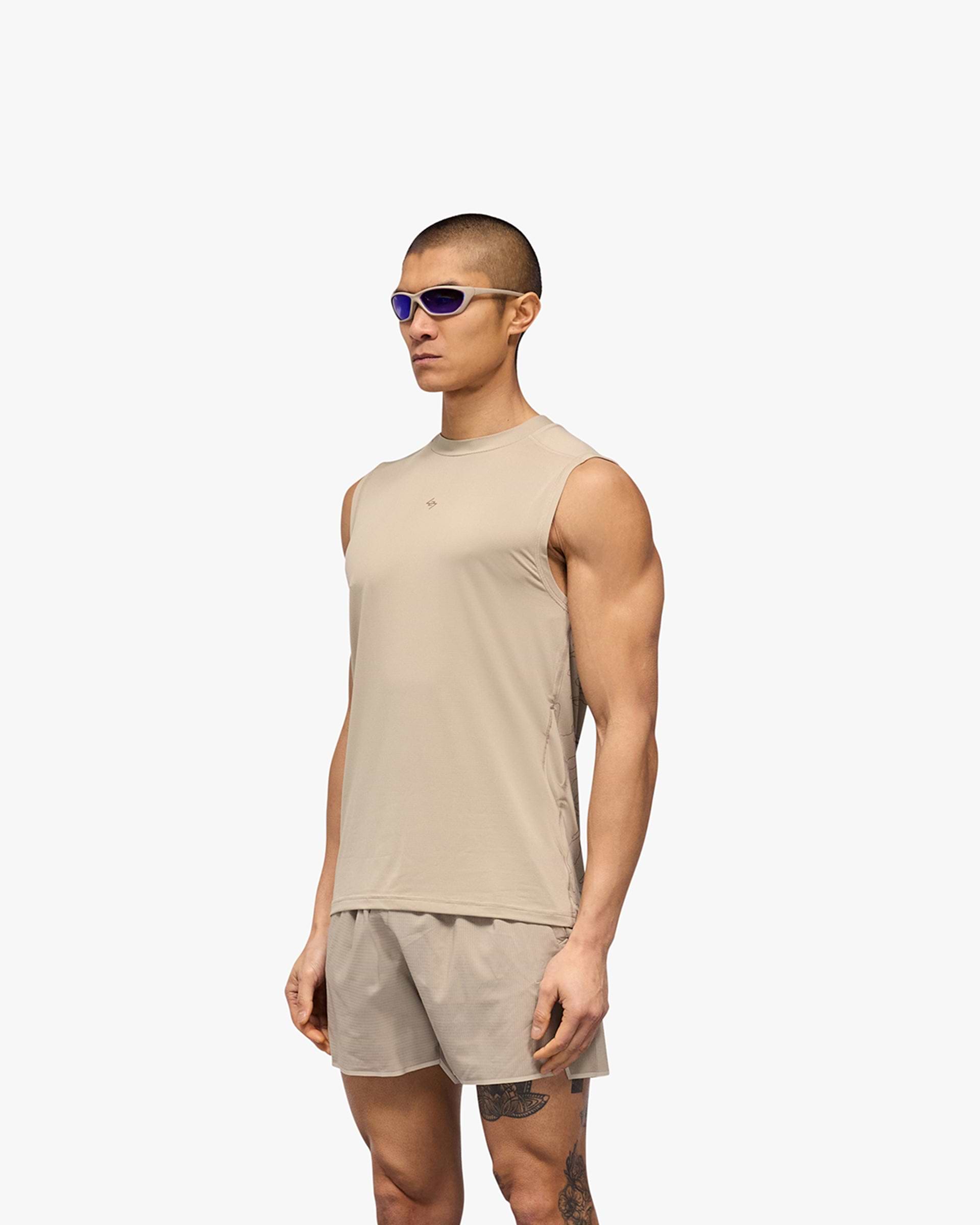 Man wearing a grey running tank on a plain white background | 247 Contour Run Tank in Pebble | Breathable mesh running tank with contour print | 247 T-Shirts | Represent Clo