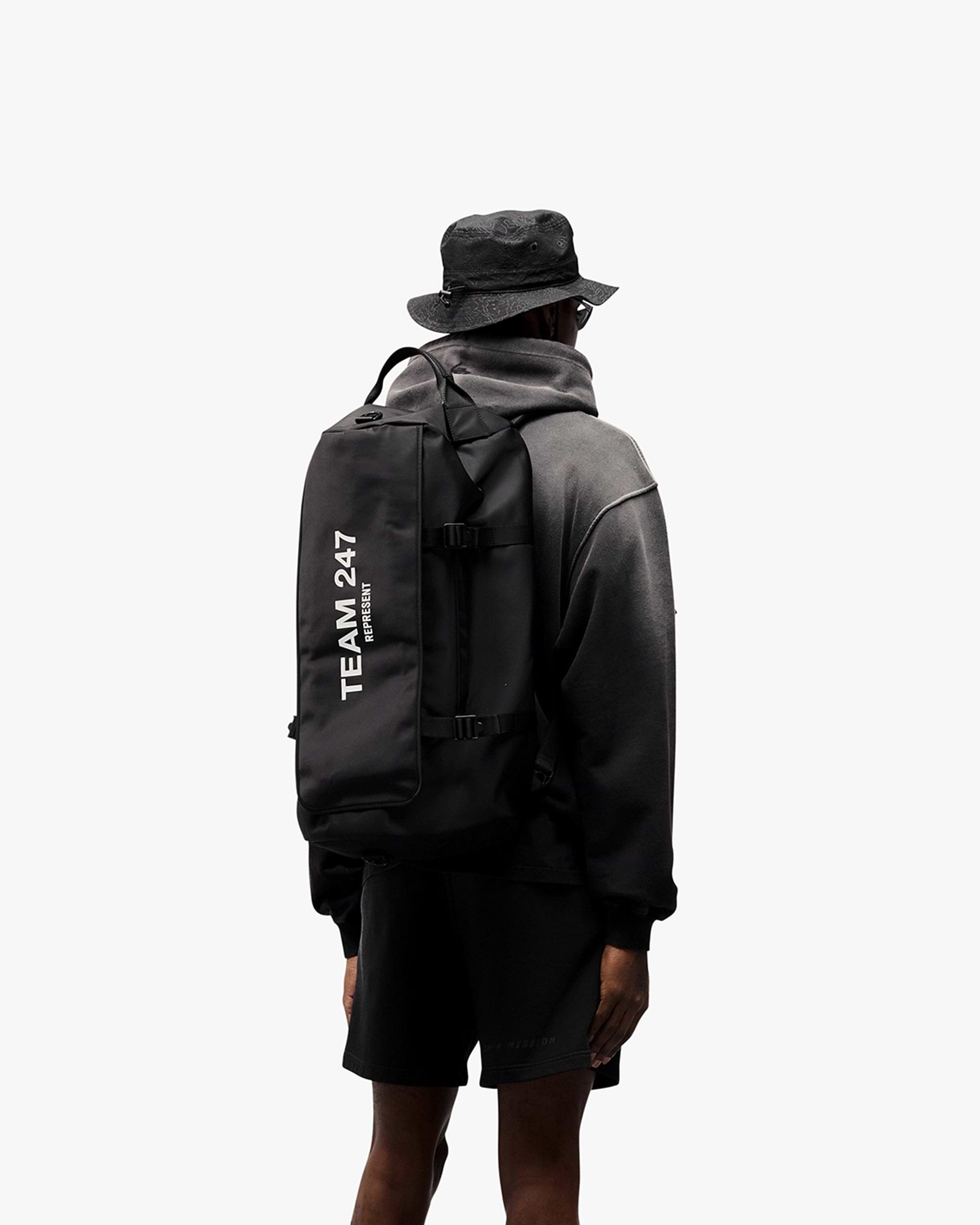 Man wearing an oversized black hoodie on a plain white background | 247 Motion Oversized Hoodie in Black | Hoodie with ribbed hems and cuffs | 247 Hoodies | Represent Clo