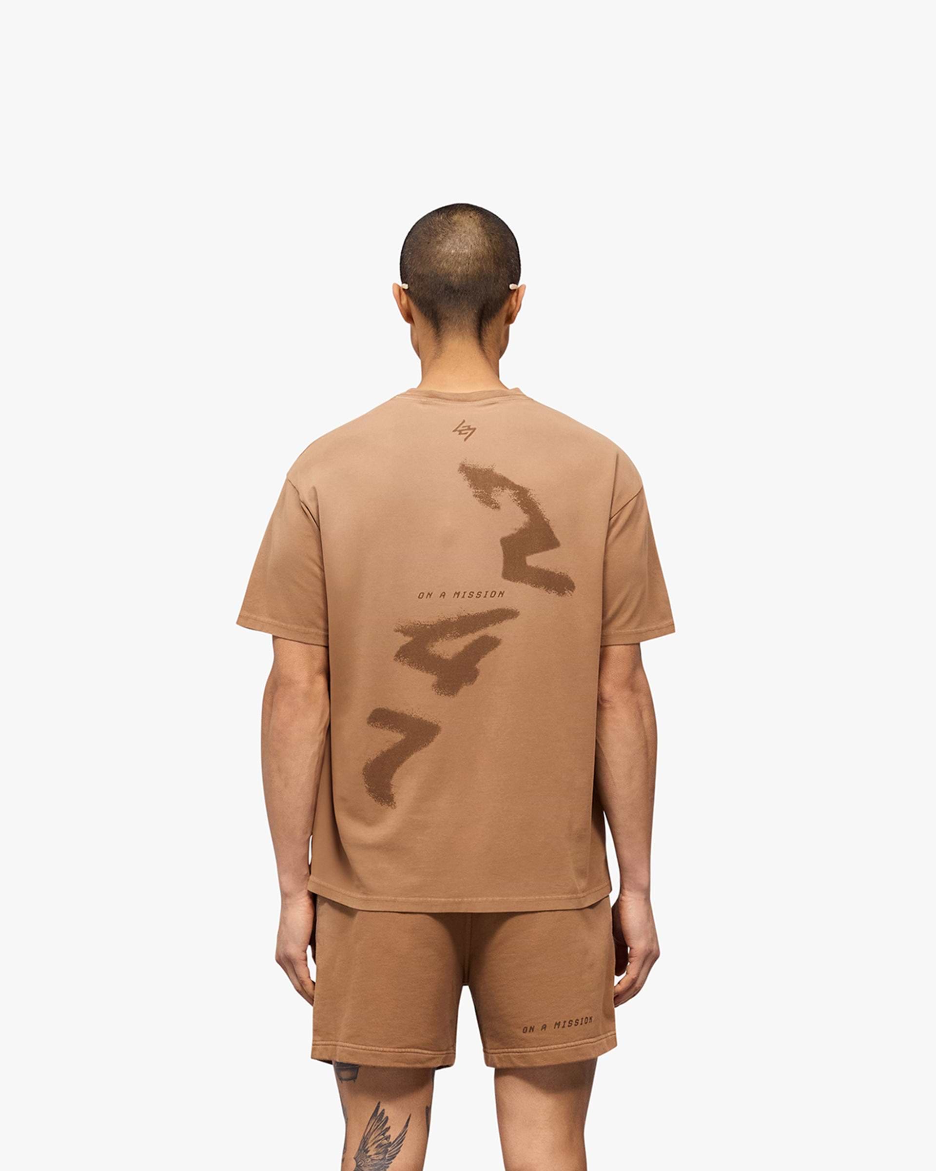Man wearing an oversized rust t-shirt on a plain white background | 247 Motion Oversized T-Shirt in Rust | T-Shirt with water based graphic print | 247 T-Shirts | Represent Clo